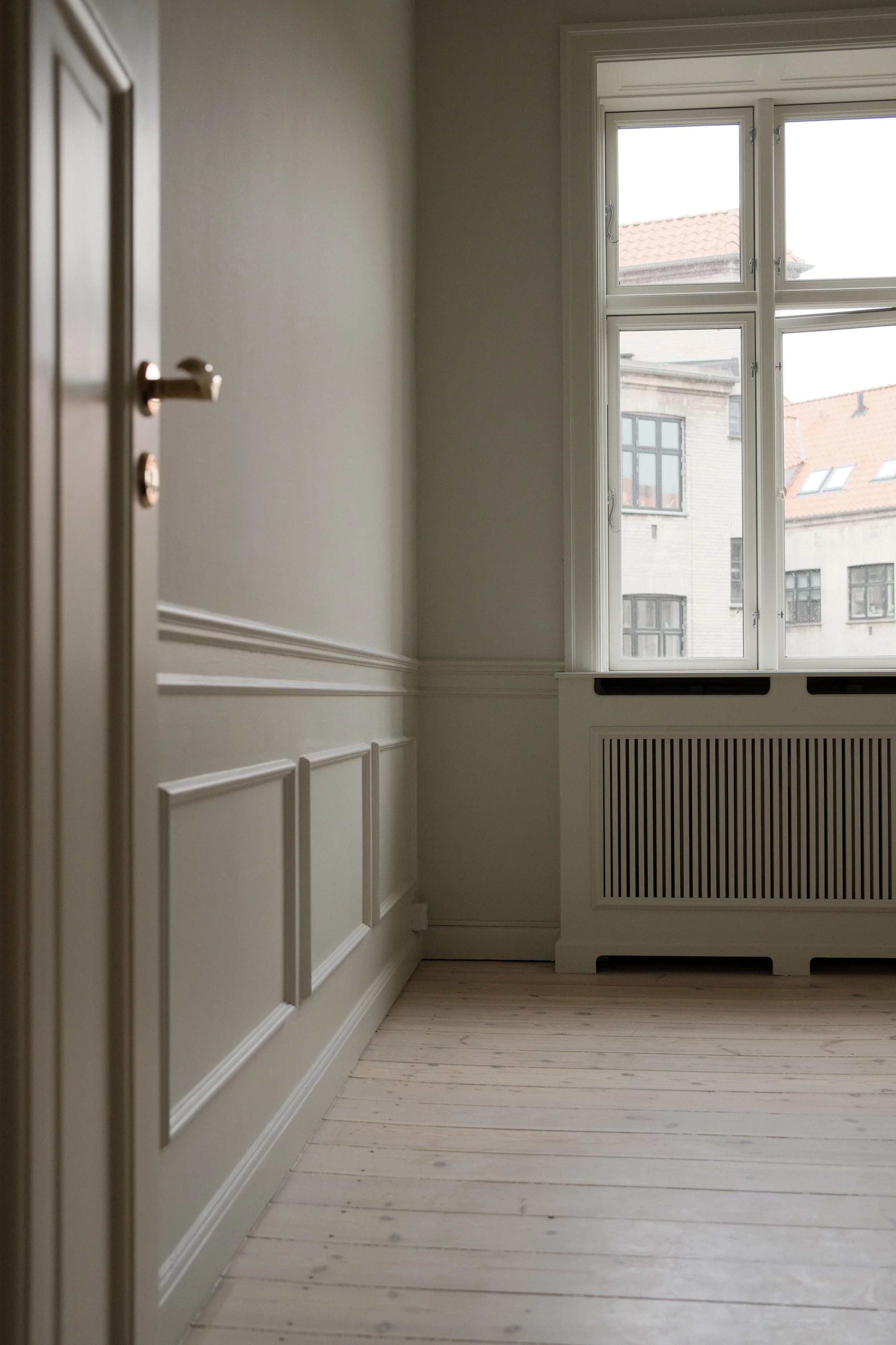 Lyst rum med trægulv og vindue efter indvendig renovering