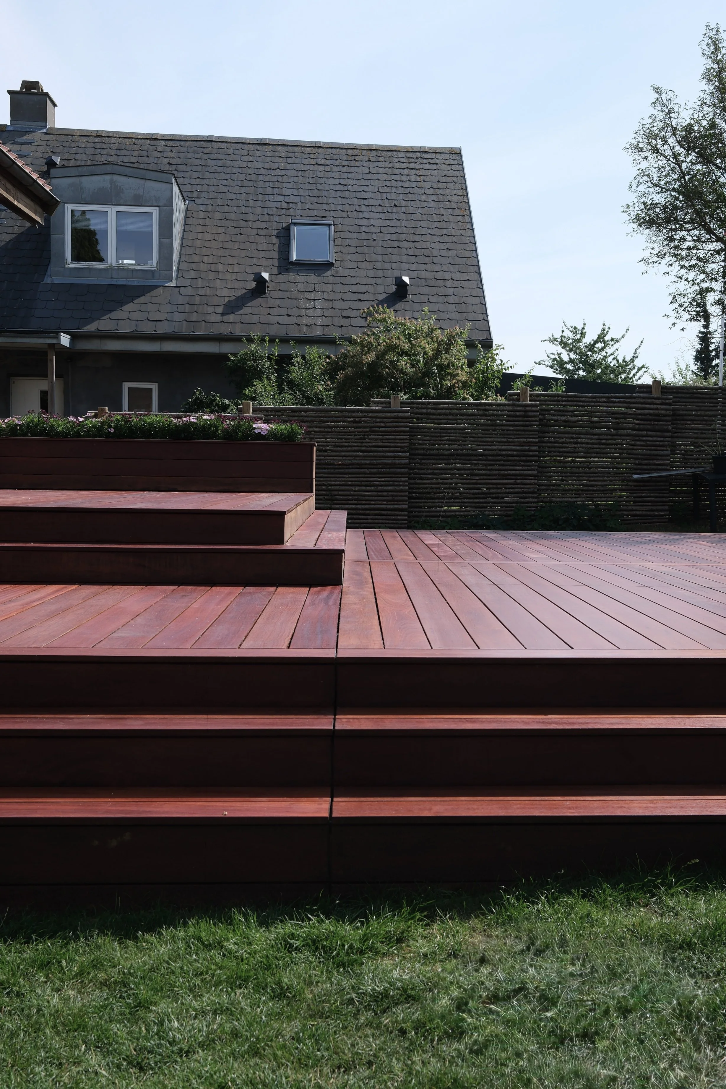Træterrasse under udførelse med opbygning og tilpasning af terrassebrædder på stedet.