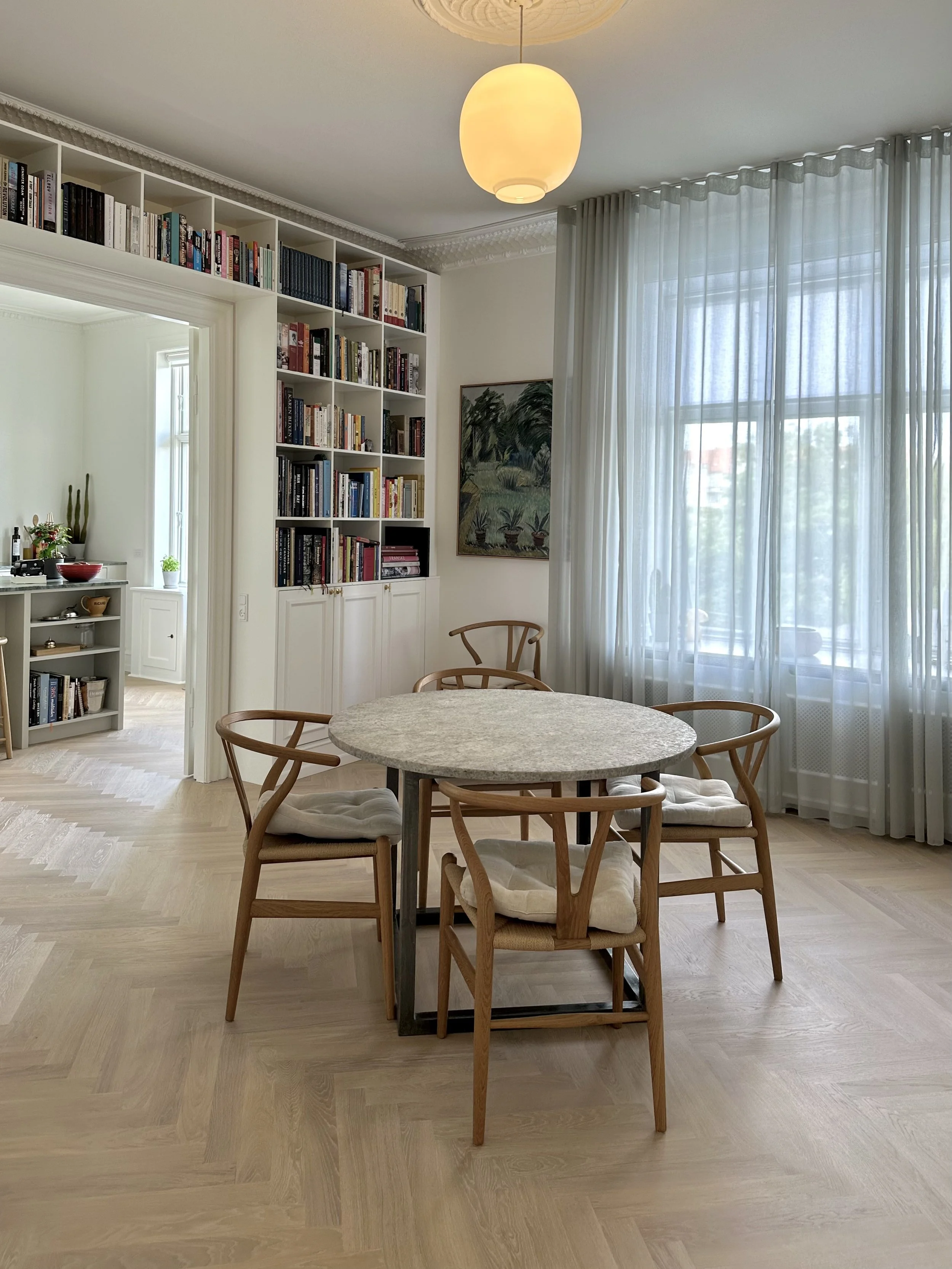 Renoveret stue og spisestue med indbyggede reoler og snedkerdetaljer