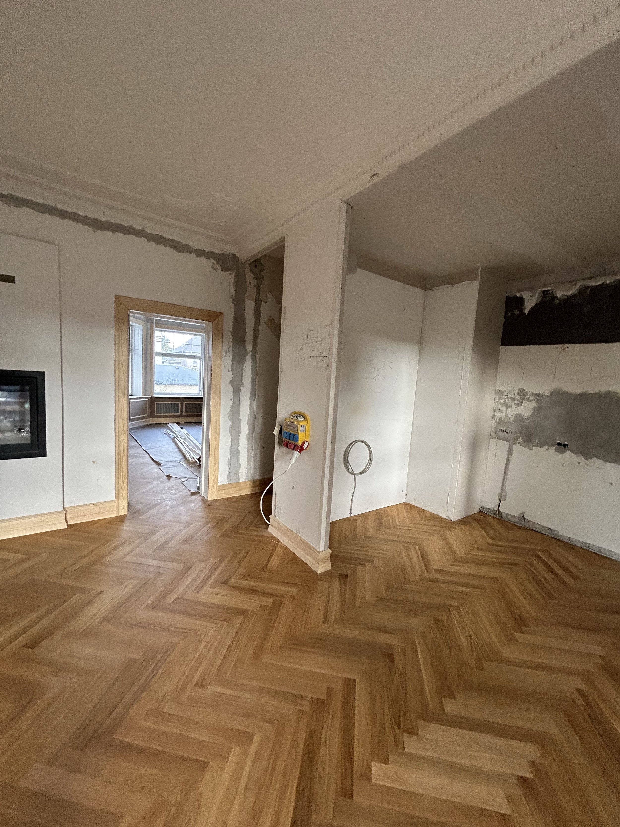 Nylagt sildebensparket under gennemgribende boligrenovering med renovering af vægge, lofter og træværk.