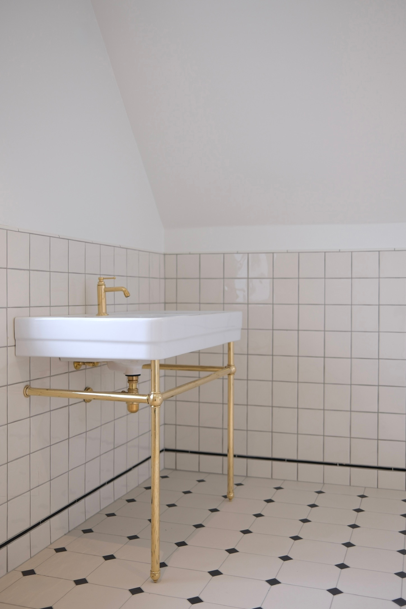 Nyt badeværelse med fliser, specialtilpasset håndvask og armaturer i messing.