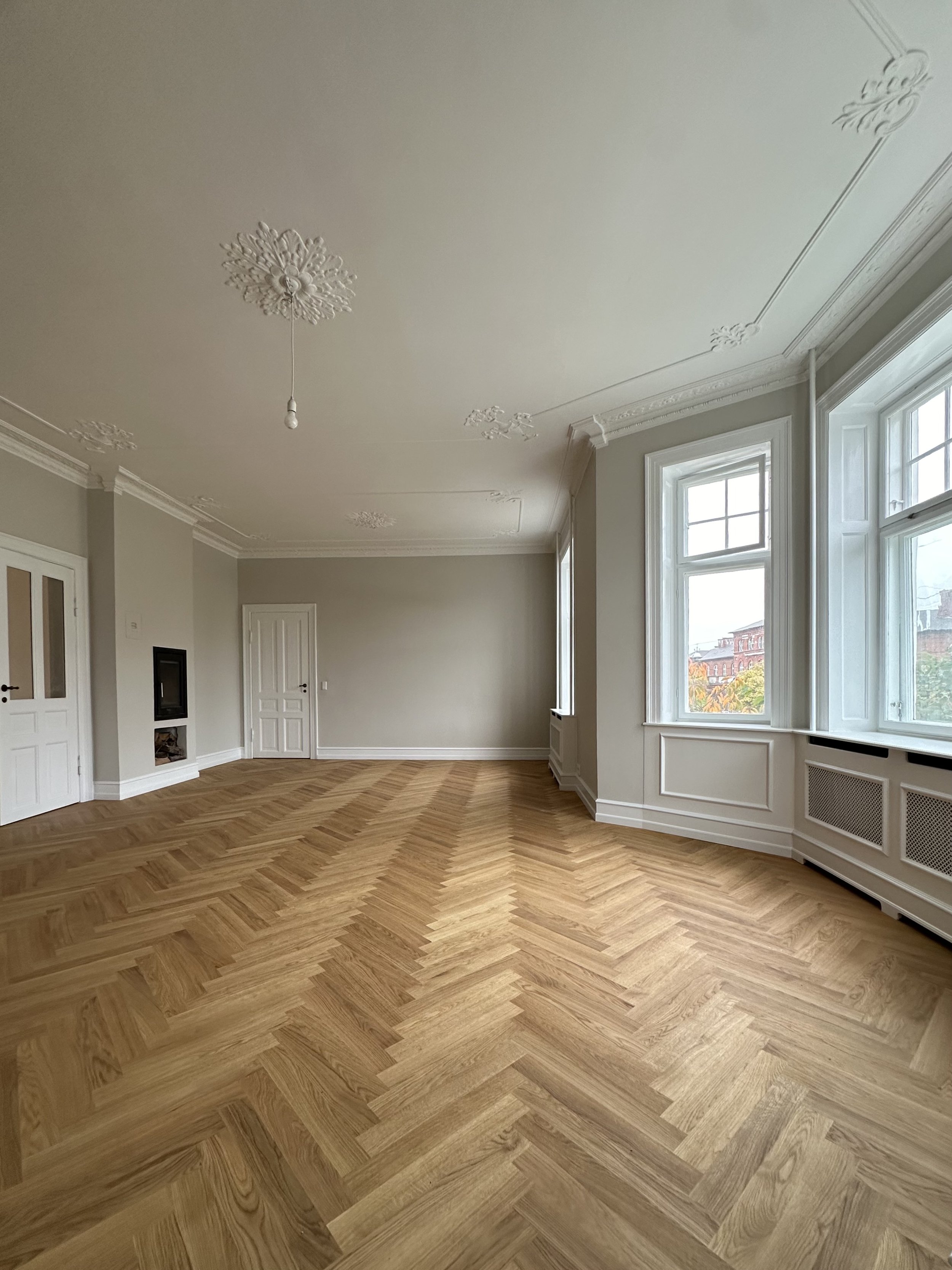 Færdigrenoveret bolig med sildebensparket, stukloft og bevarede klassiske detaljer.