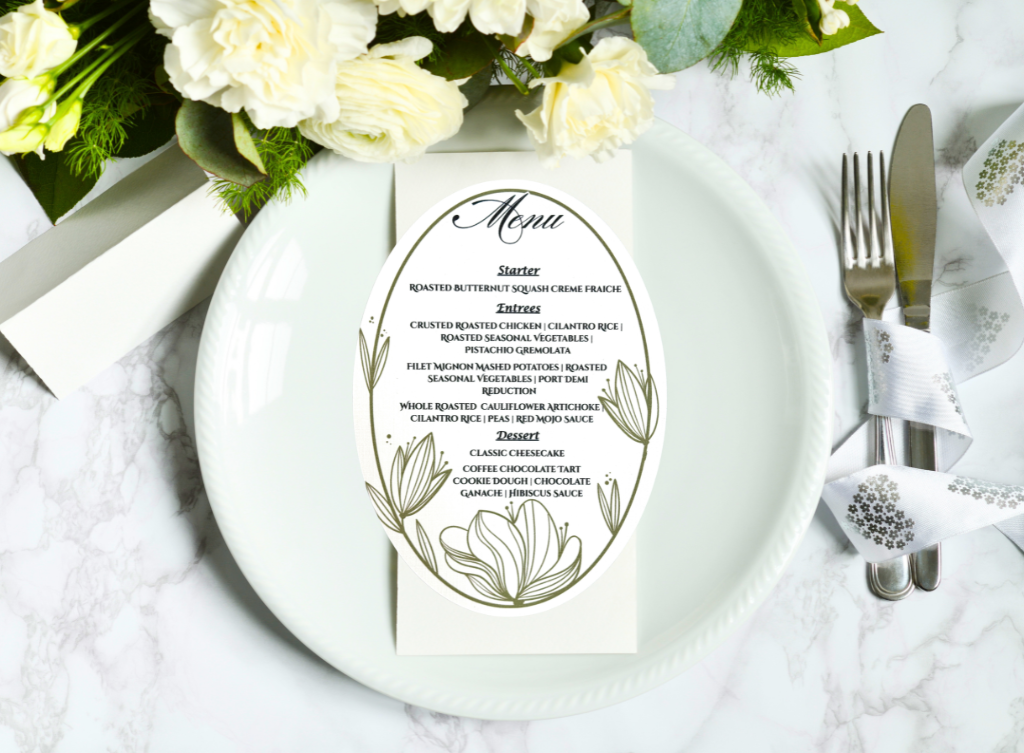 An elegant oval dinner menu used for a wedding reception table decorated with floral decor in olive green and black designs