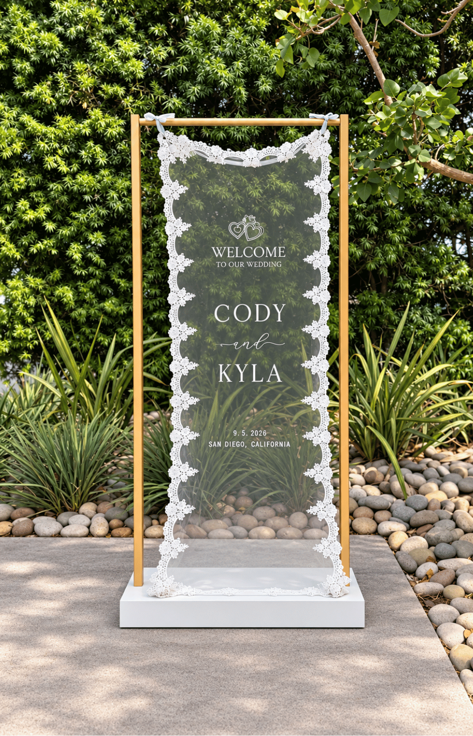 White Lace Fabric Sign with white writing welcome to our wedding displayed on atalle gold stand