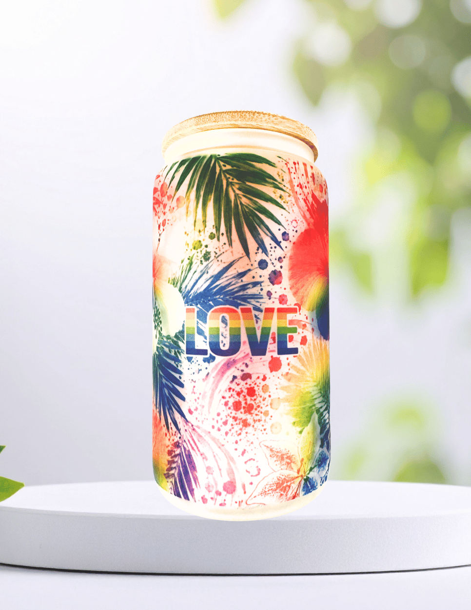 Tropical Pride 16 oz glass tumbler with colorful rainbow hibiscus flowers, bamboo lid, and reusable straw.