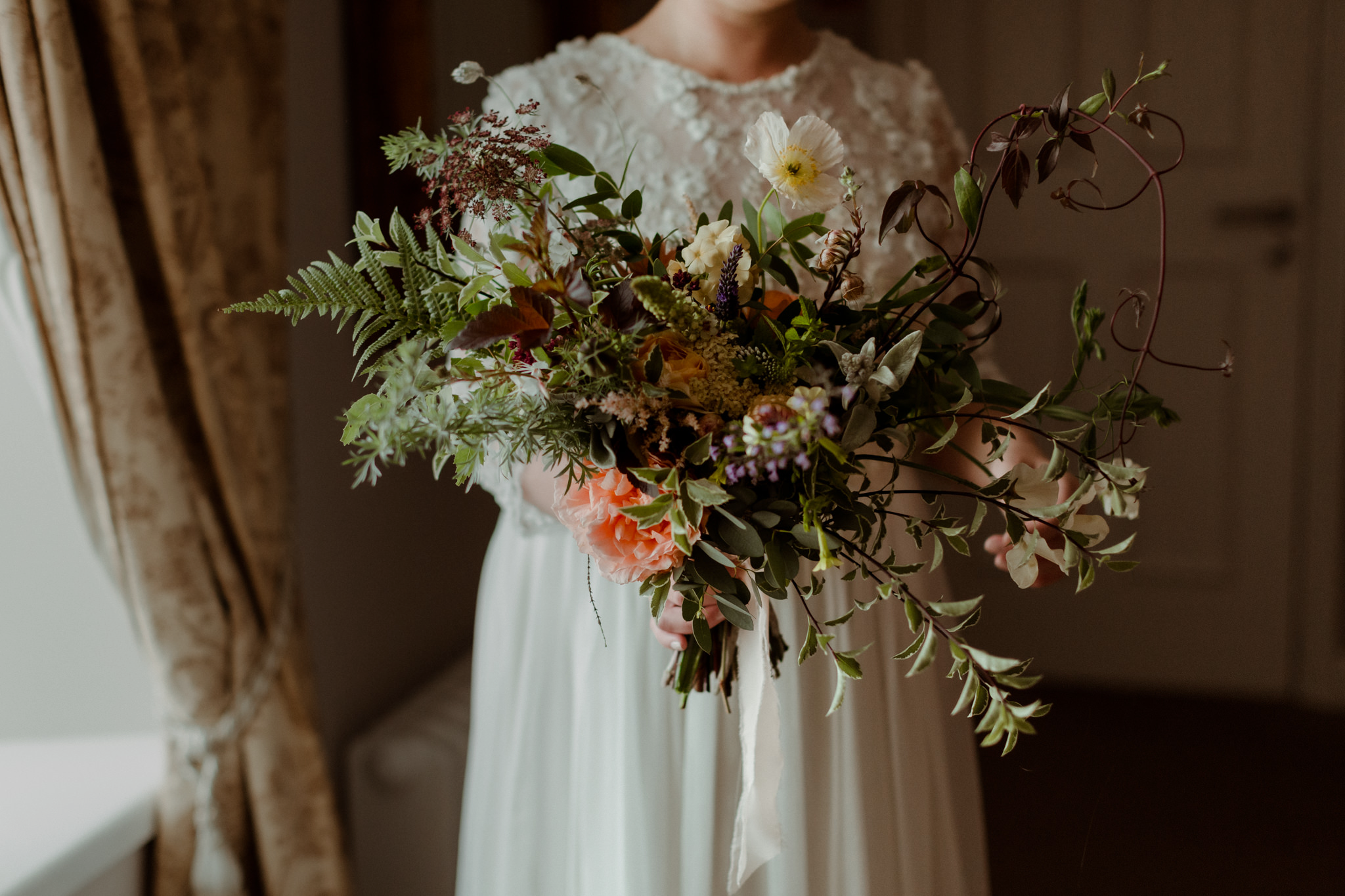 Bride in classic white lace dress holding bespoke organic Devon-grown natural flower bouquet