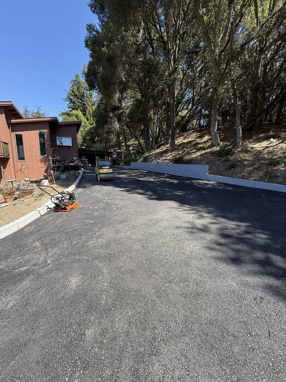 Rebuilt driveway leading to the garage, with the retaining wall and curb along the hillside