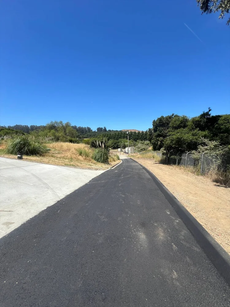 New asphalt road and curbing on a rural property