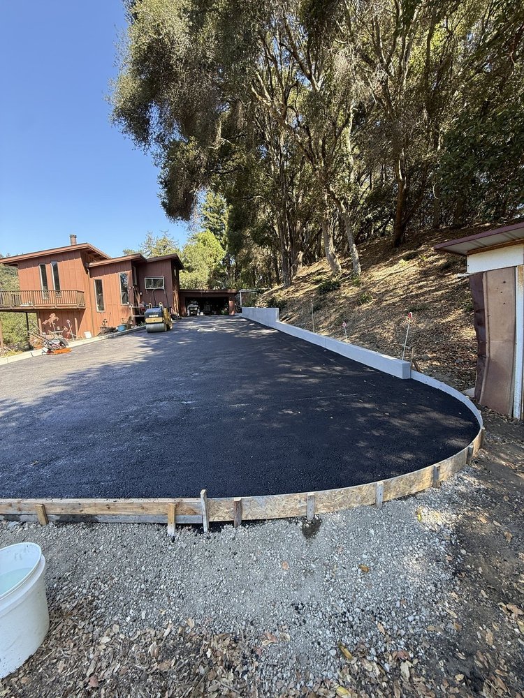 Finished asphalt turnaround with a new concrete retaining wall in Aptos