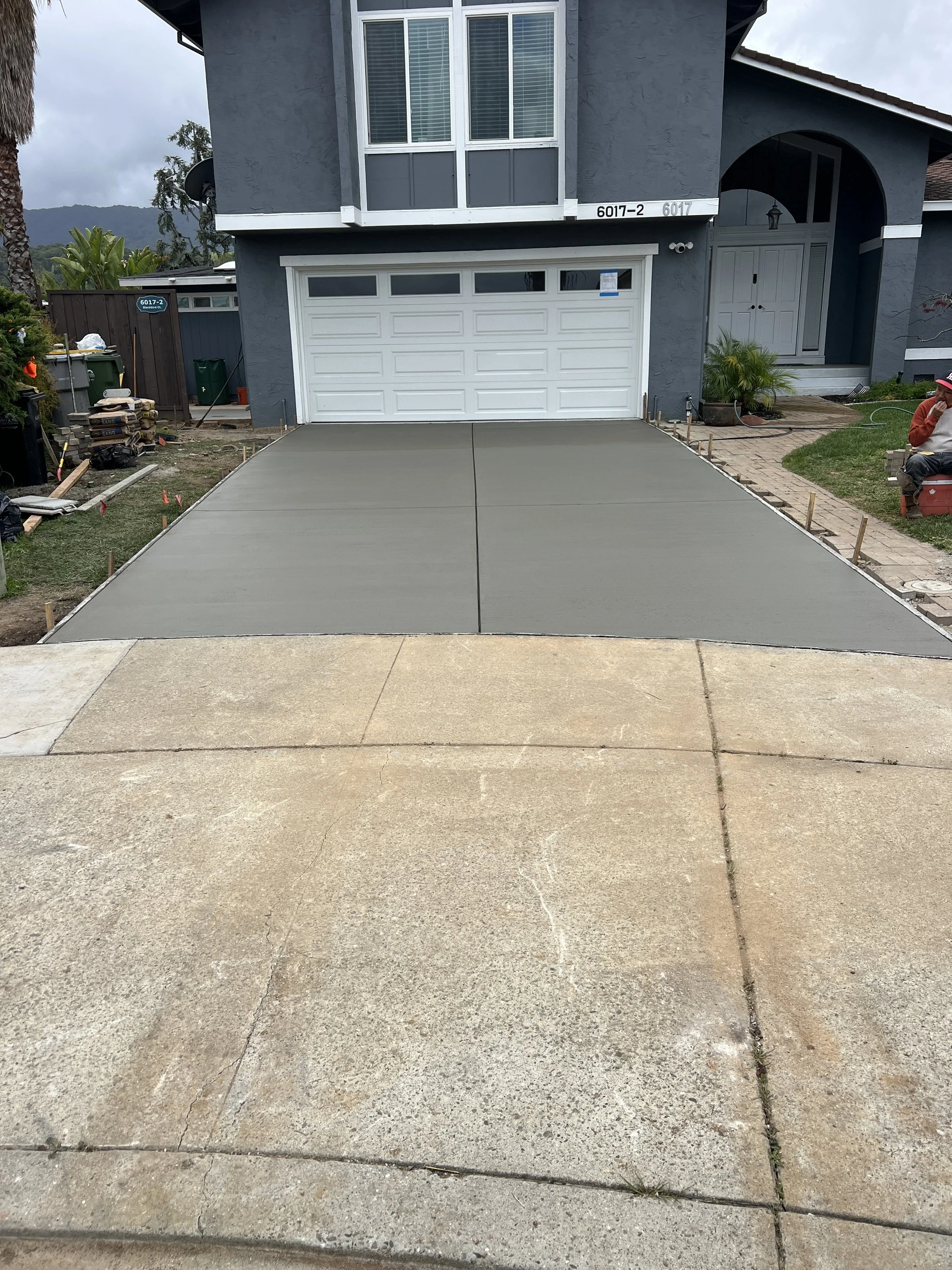 Finished concrete driveway after flat work with smooth surface next to old driveway