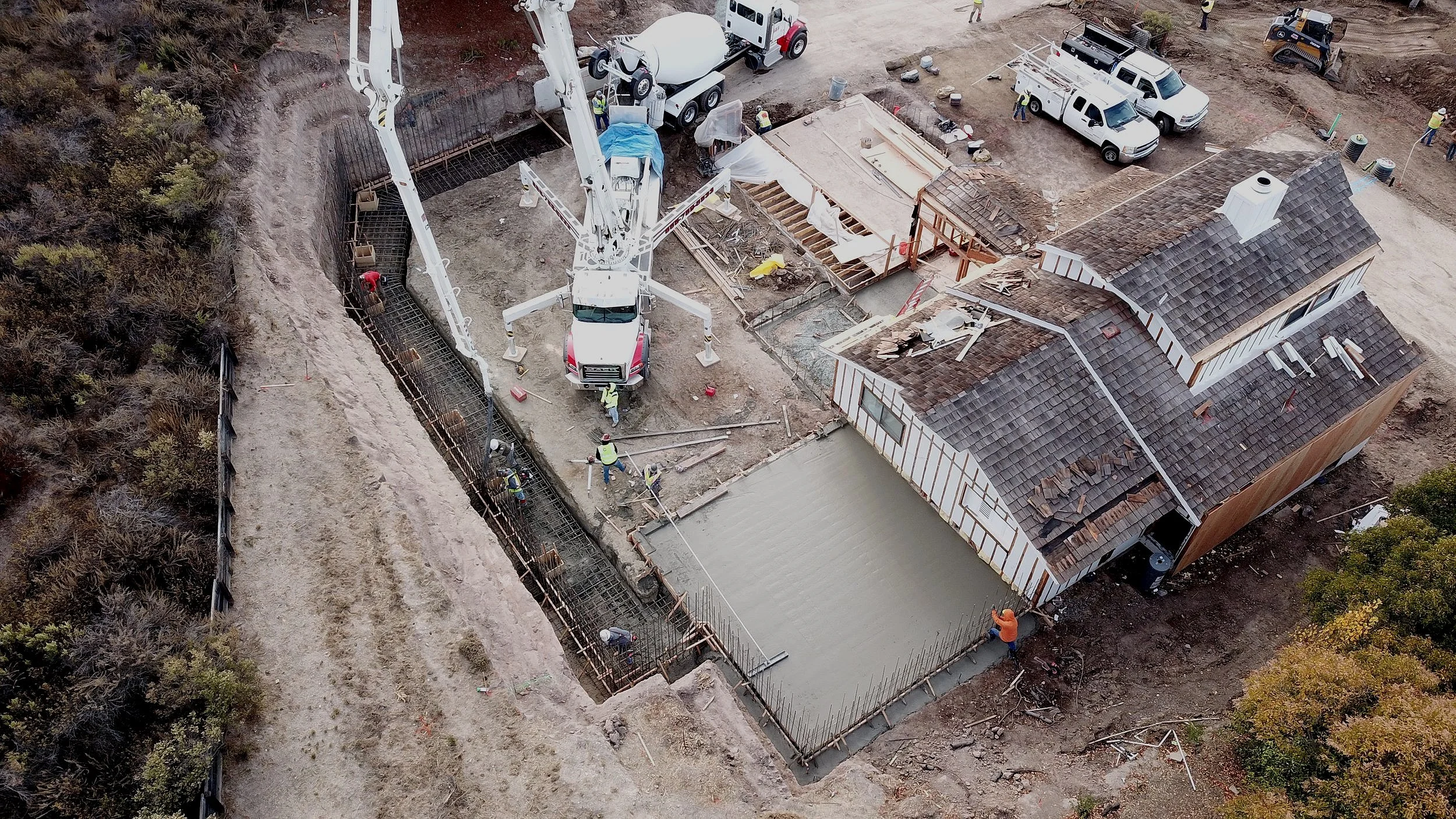 Aerial view of a residential site with concrete placement, grading and site access work