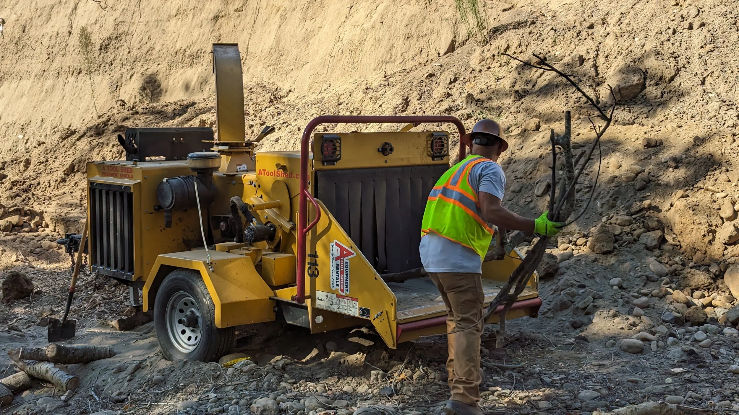 Freedom Earthworks crew clearing brush with a wood chipper
