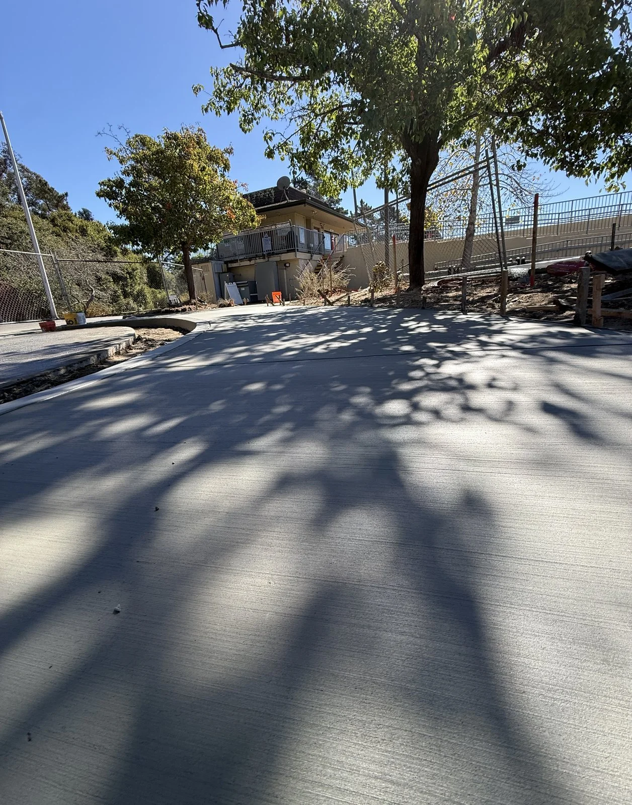 Finished broom-finish concrete walkway leading to the existing walkway and asphalt