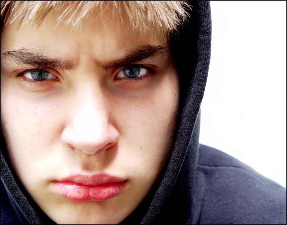 Teen boy with hoodie looking angry