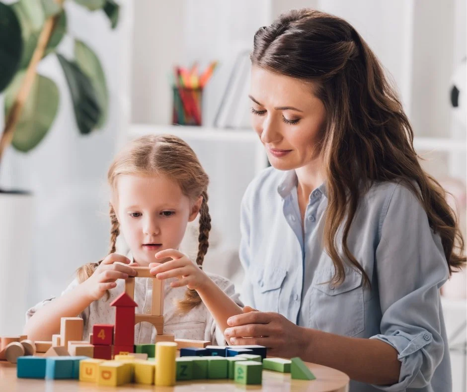 Young girl and Mother building blocks together
