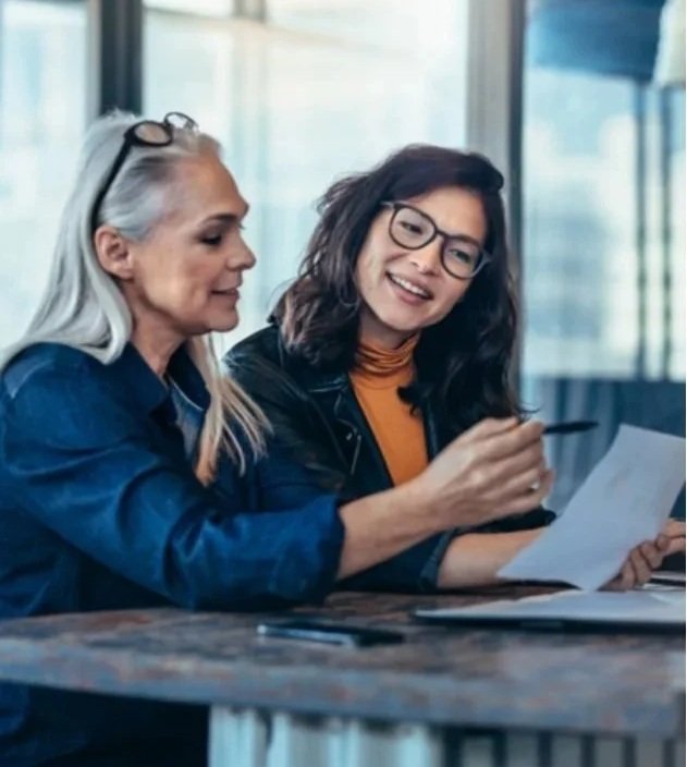 Two women talking at a table looking at a piece of paper