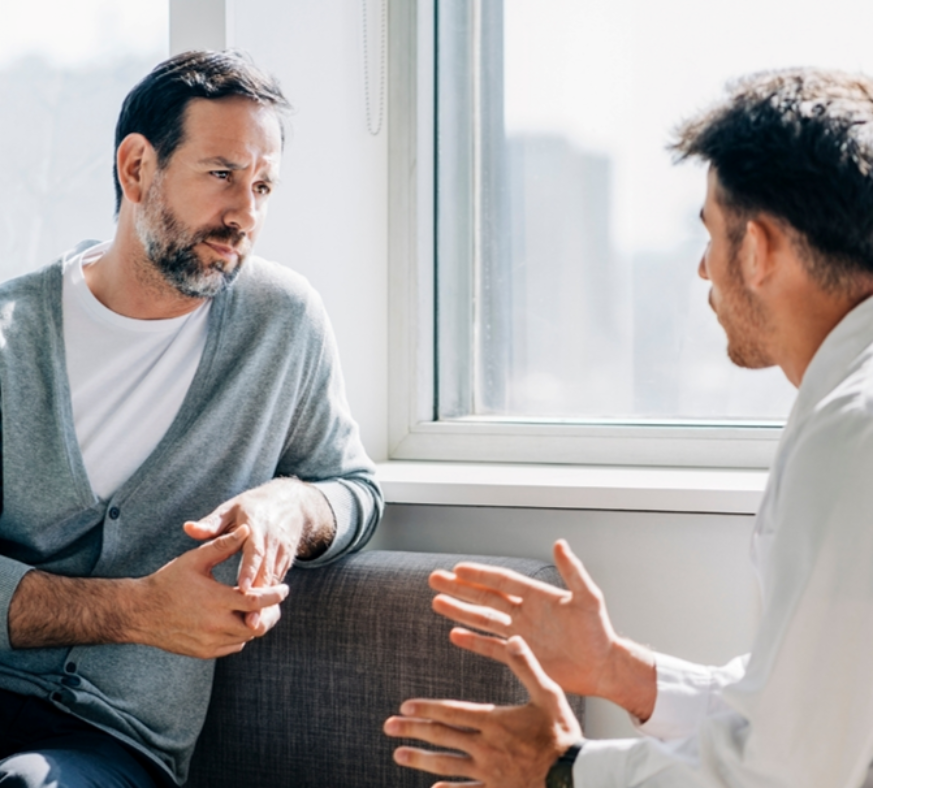 Two business men sitting by a window talking