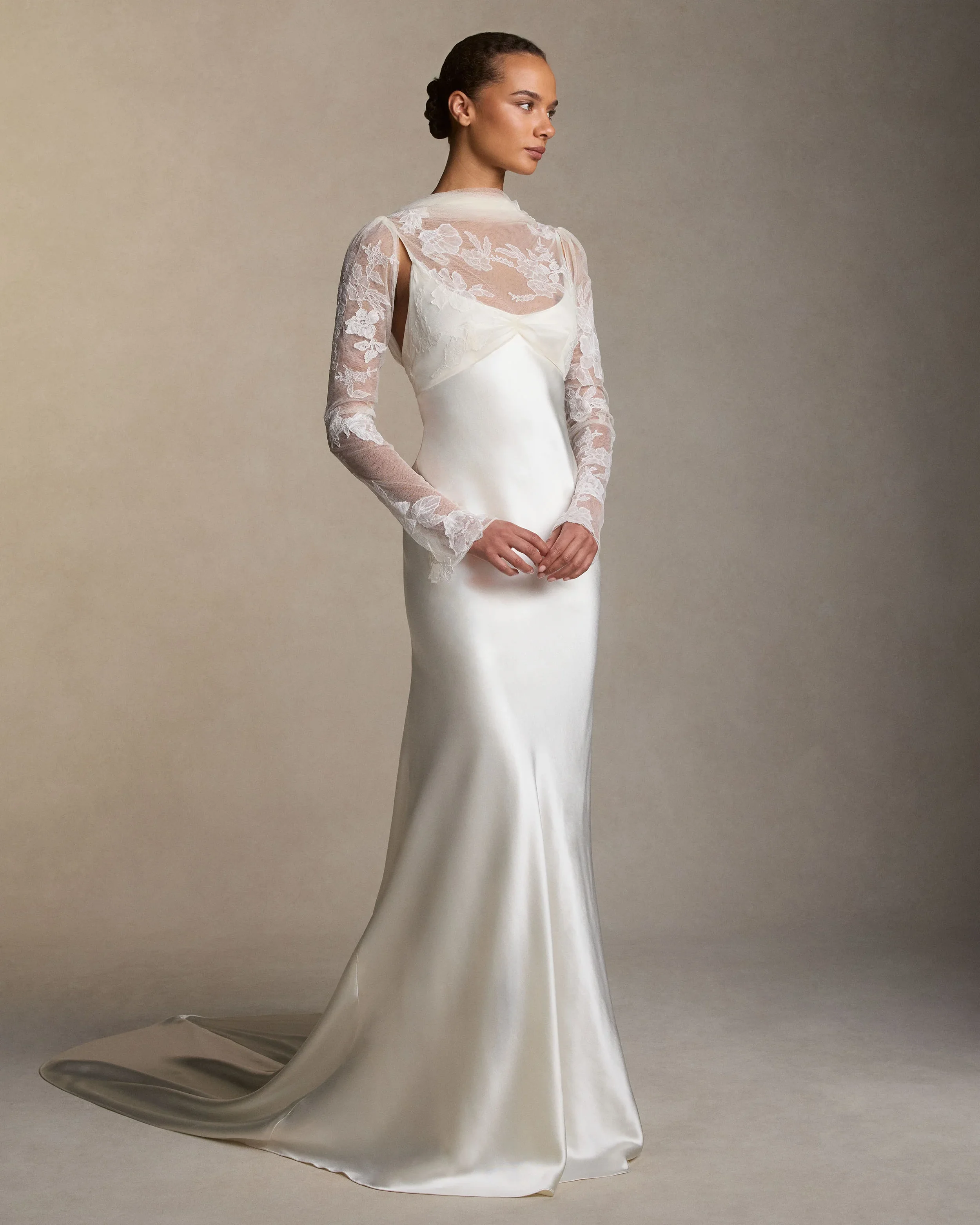 Bride wearing a sleek slip silhouette wedding dress with lace sleeves and details in ivory silk satin and ivory French lace.