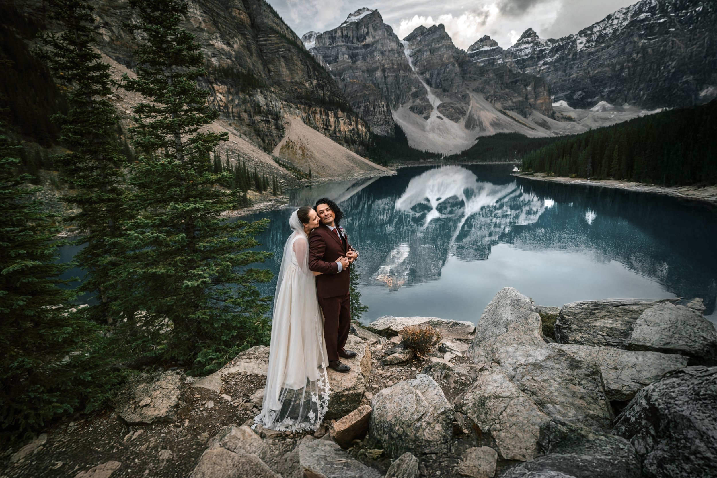 Bride and groom at Moraine Lake with mountain backdrop