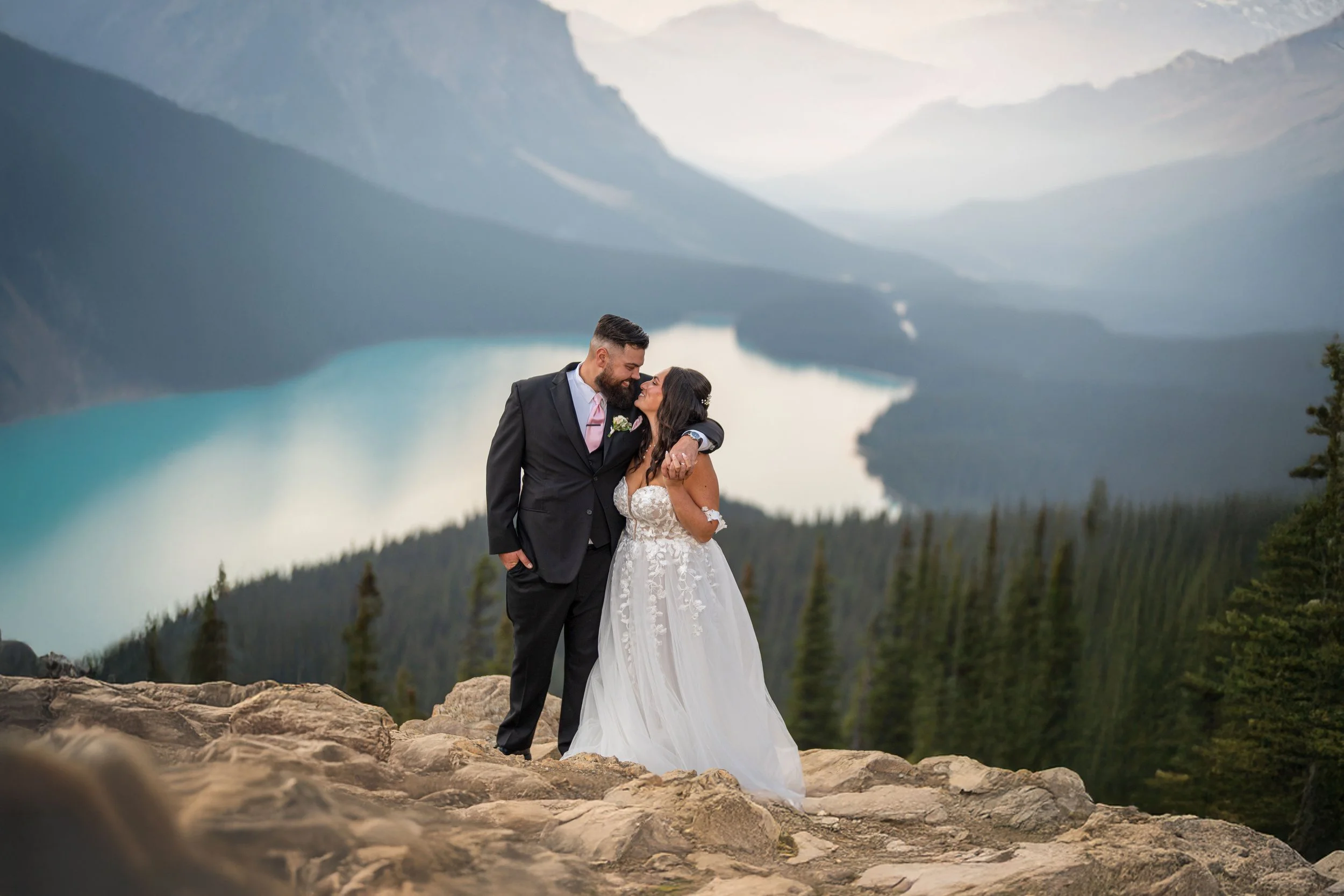 Bride and groom embracing above Peyto Lake in Banff