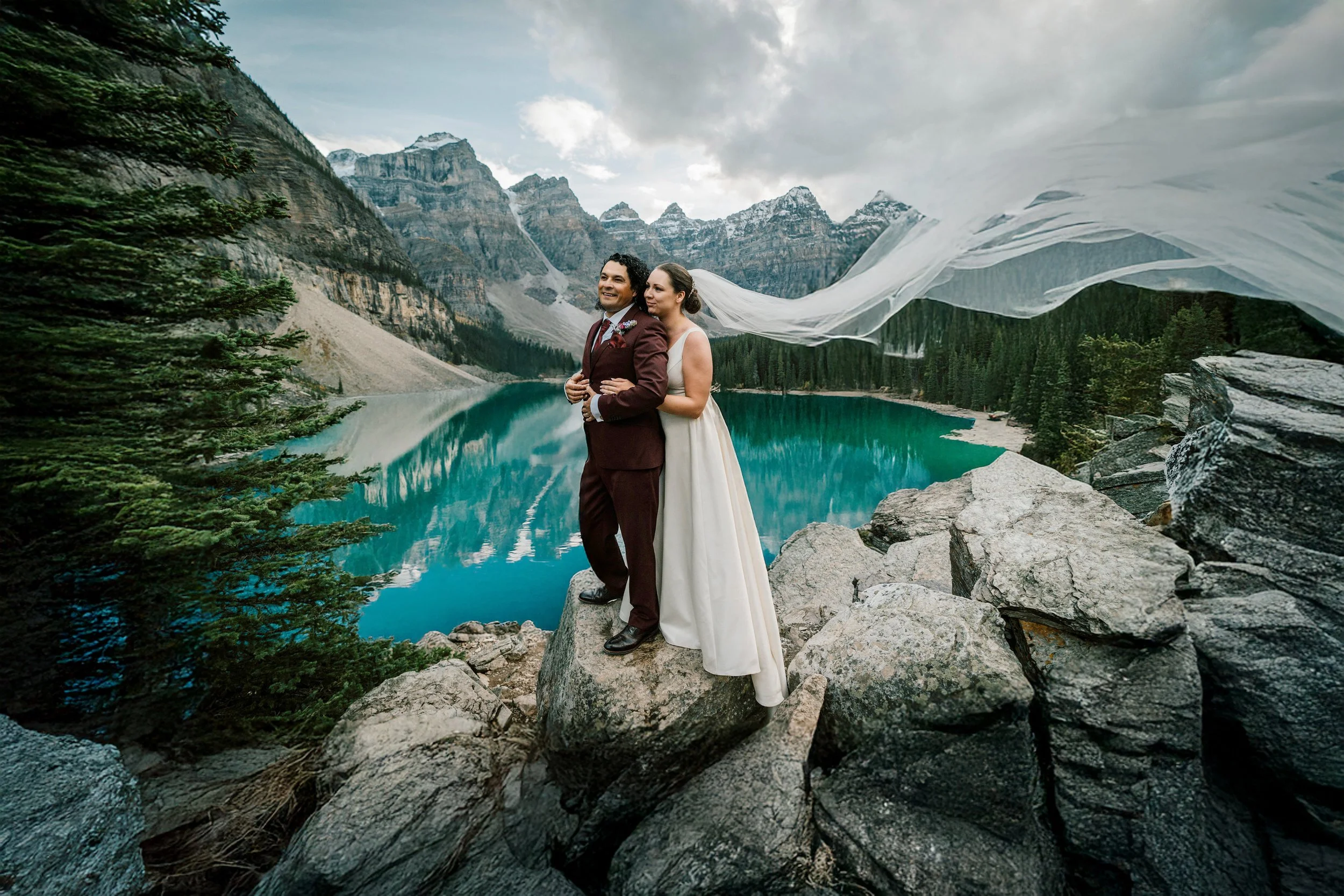 Couple standing on the rocks at Moraine Lake during their wedding in Banff National Park, Alberta