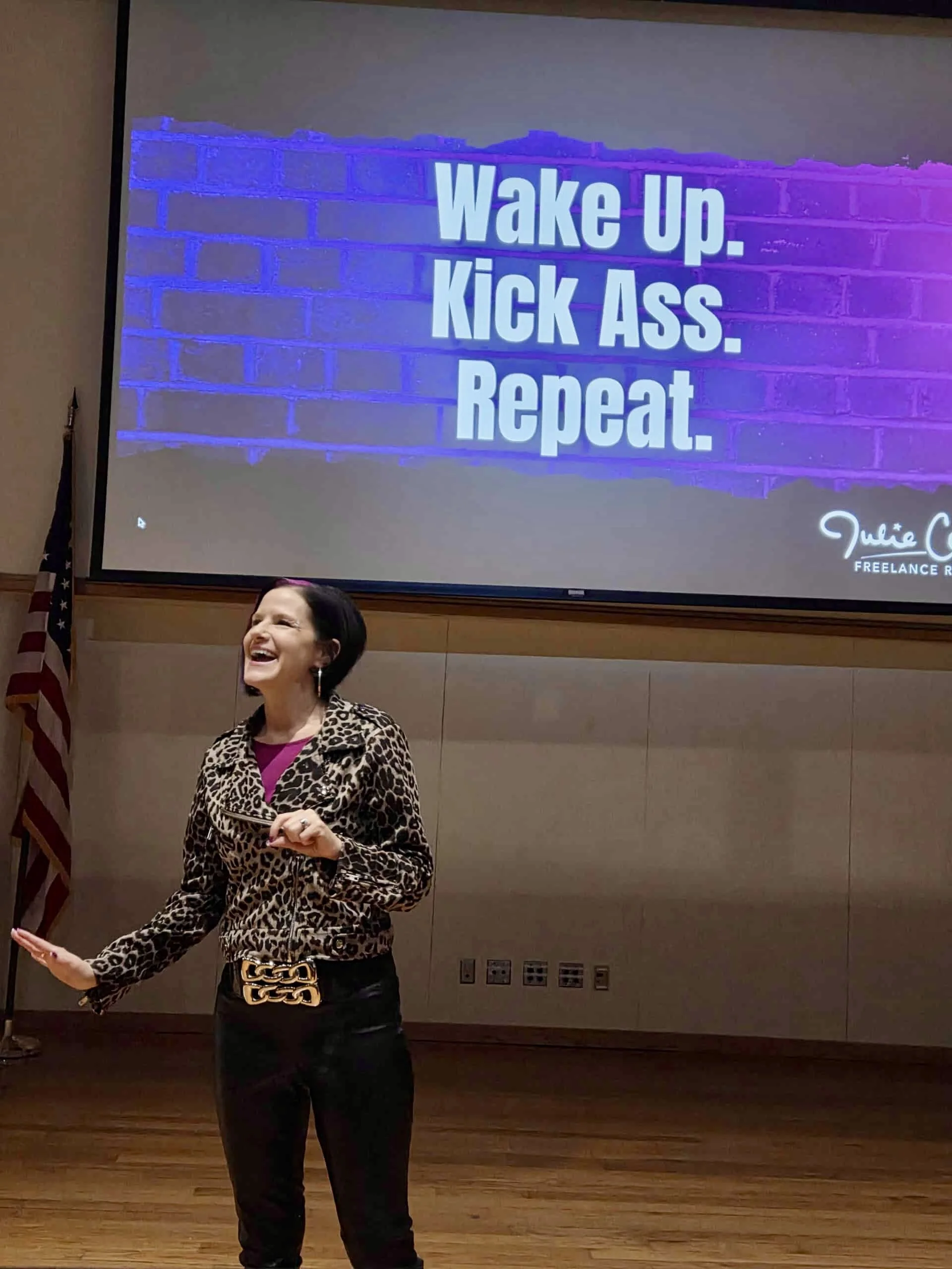 Pic of Julie Cortés speaking at Juco last year. Presentation slide behind her reads: "Wake up. Kick ass. Repeat."