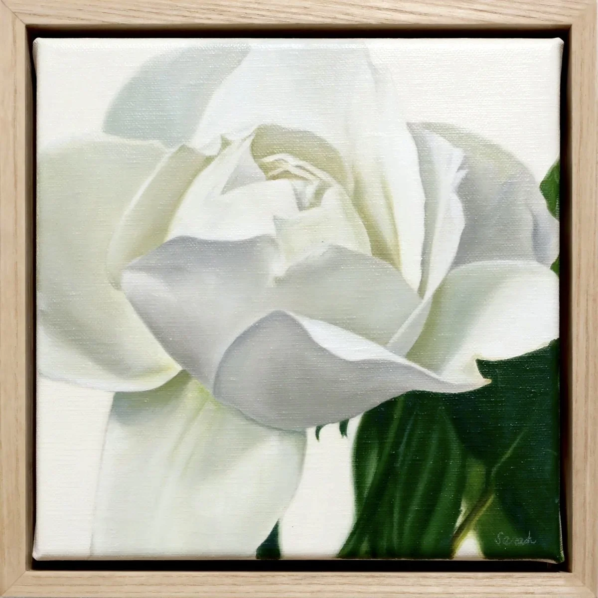 Painting of a white flower with green leaves in a wooden frame.
