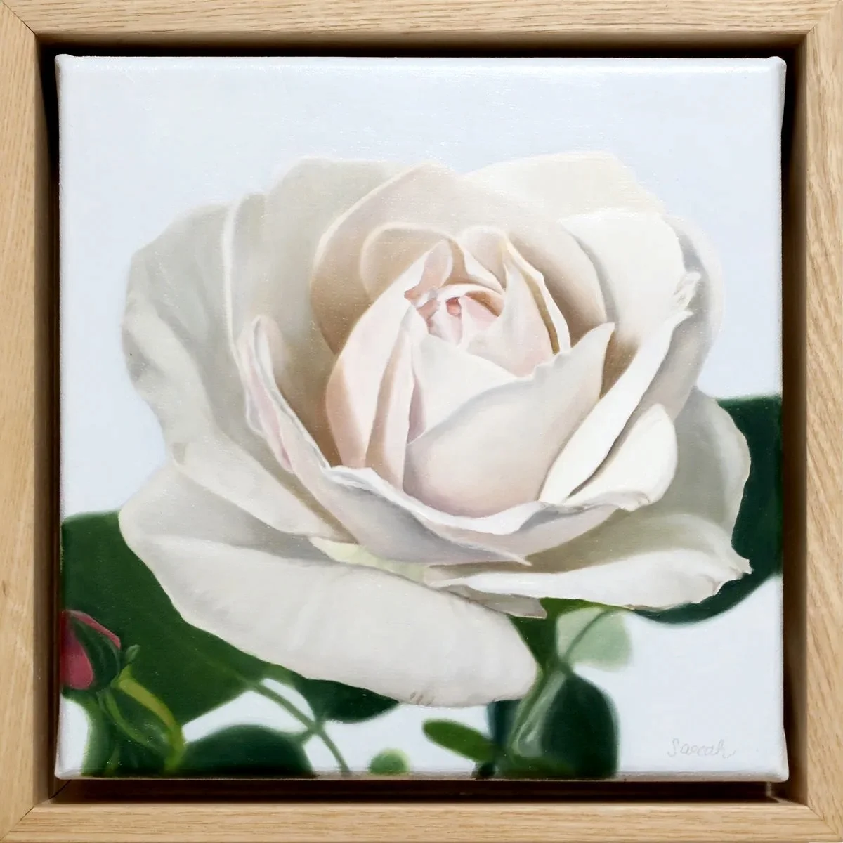Painting of a white rose with green leaves in a wooden frame.