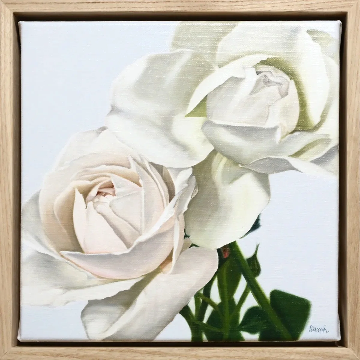 A framed painting of three white roses with green stems and leaves.