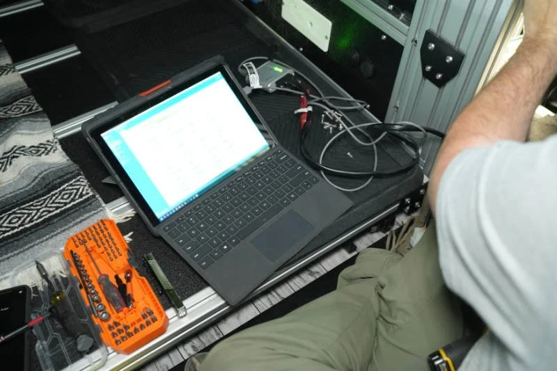 Nimbl Vehicles technician performing diagnostic testing on an Eberspächer heater inside a camper van.