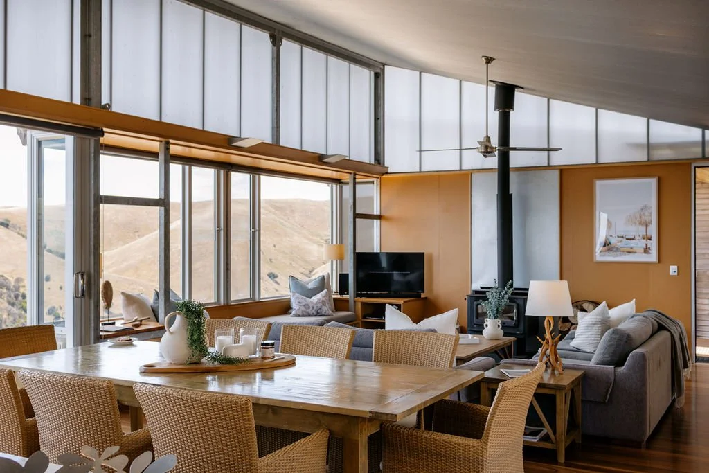 Open Living and dining room with wooden table and 8 chairs  and 2 lounges