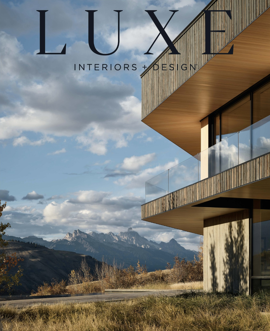 Modern building with wooden accents and glass balconies against a mountain and cloudy sky background, with text 'LUXE INTERIORS + DESIGN'.
