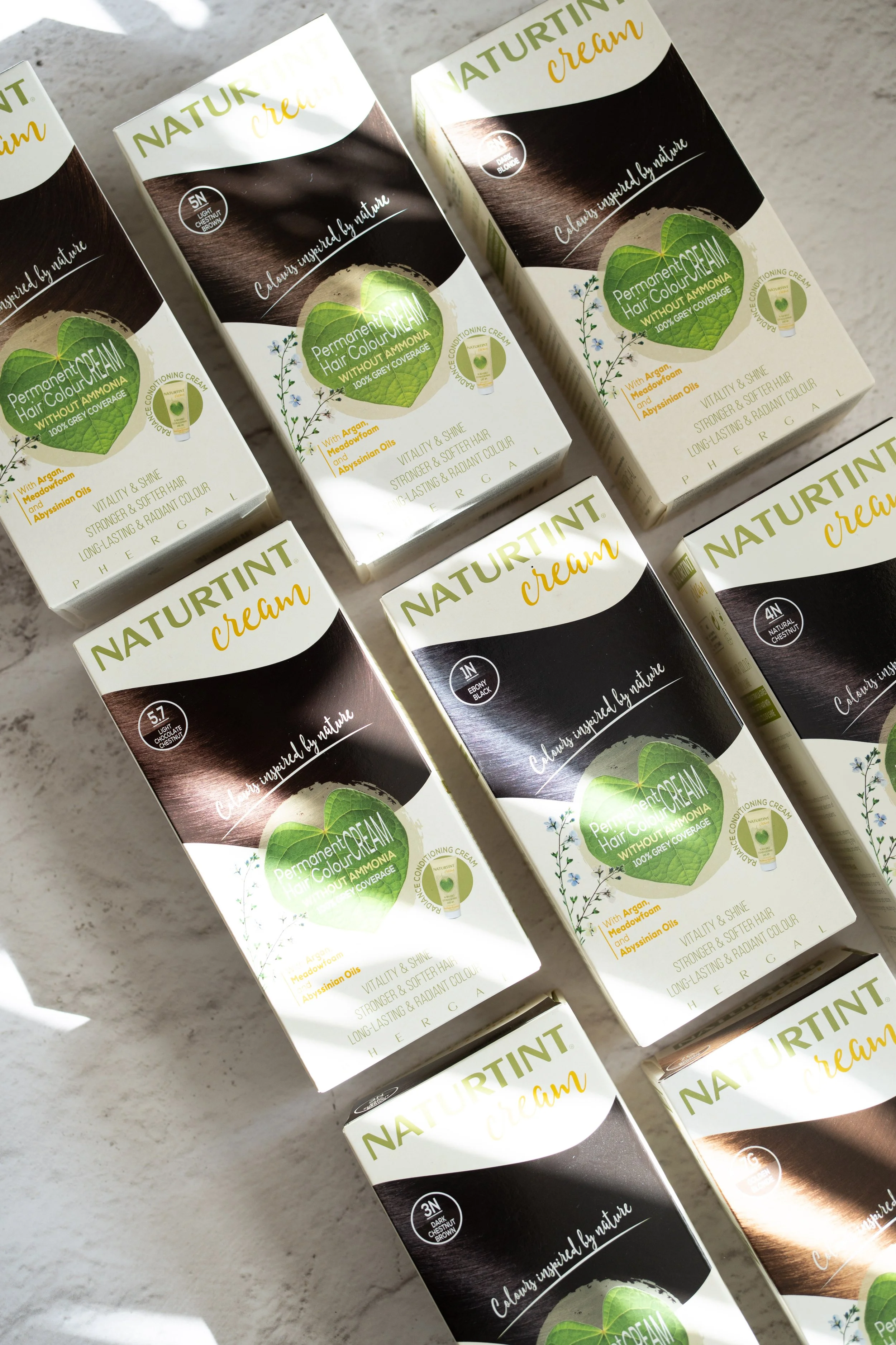 Naturtint permanent hair colour boxes arranged in natural light for creative brand photography
