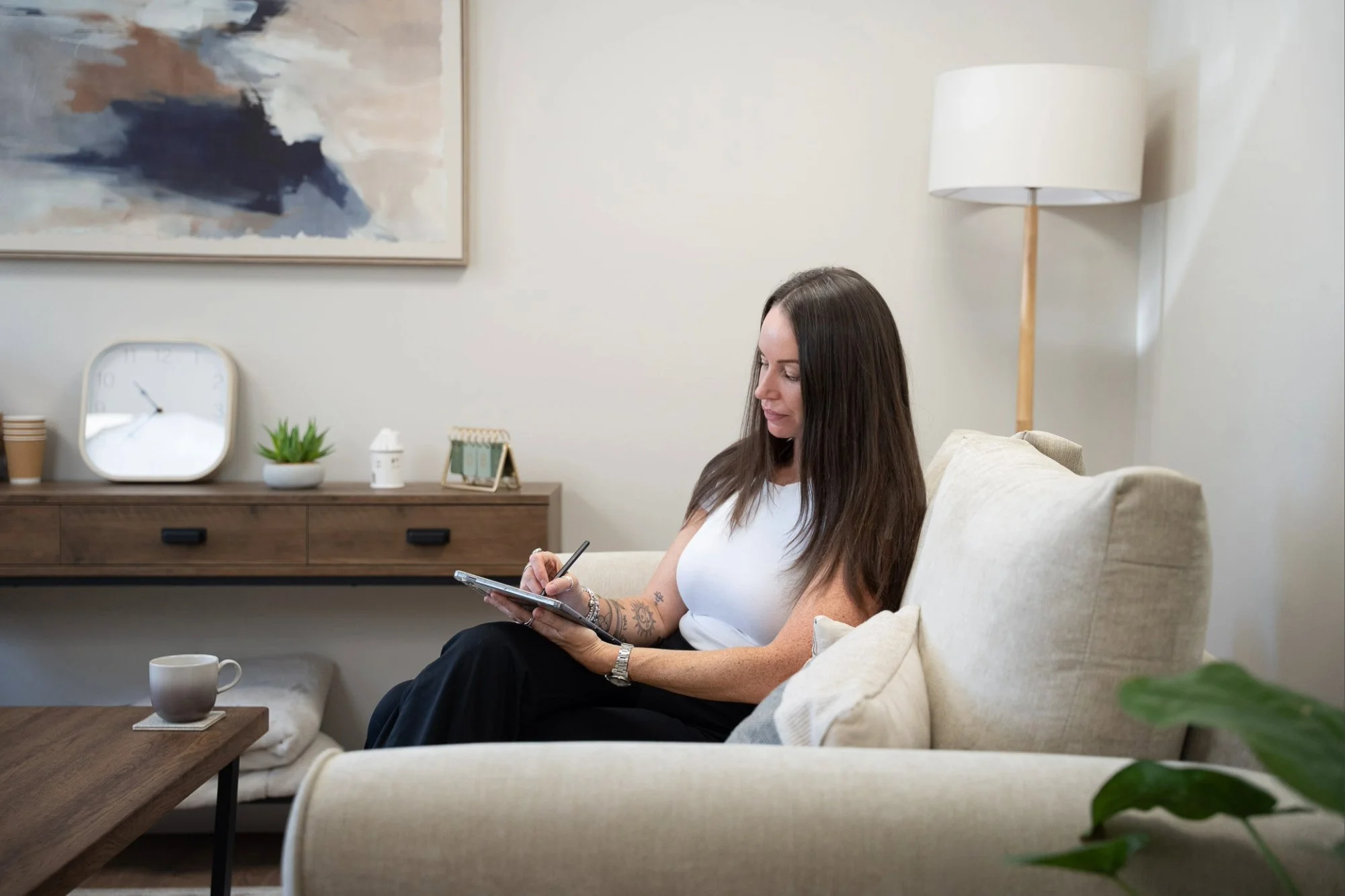 Katie from Kokoro Wellness writing during a hypnotherapy session in her therapy space.
