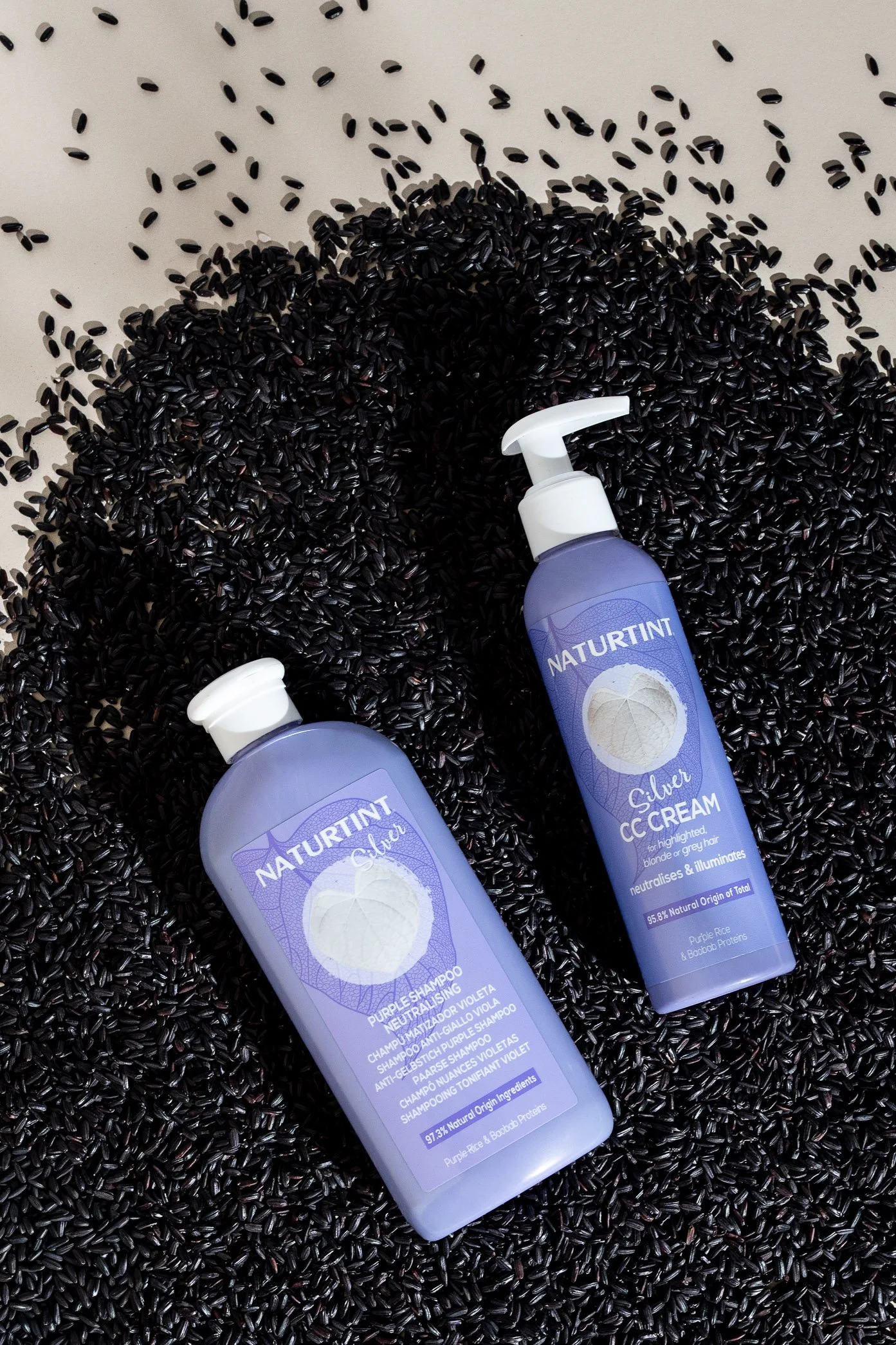Naturtint silver haircare products styled against black rice for a creative product photograph