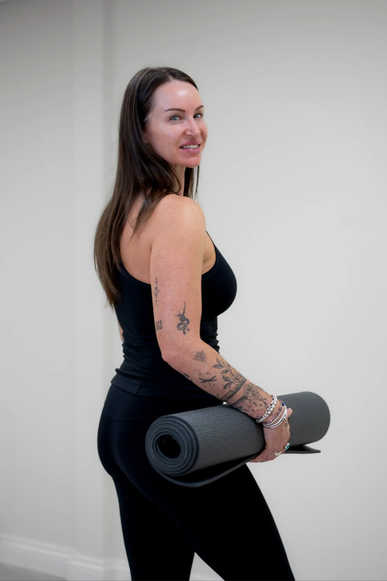 Katie from Kokoro Wellness holding a yoga mat during her personal branding photoshoot.