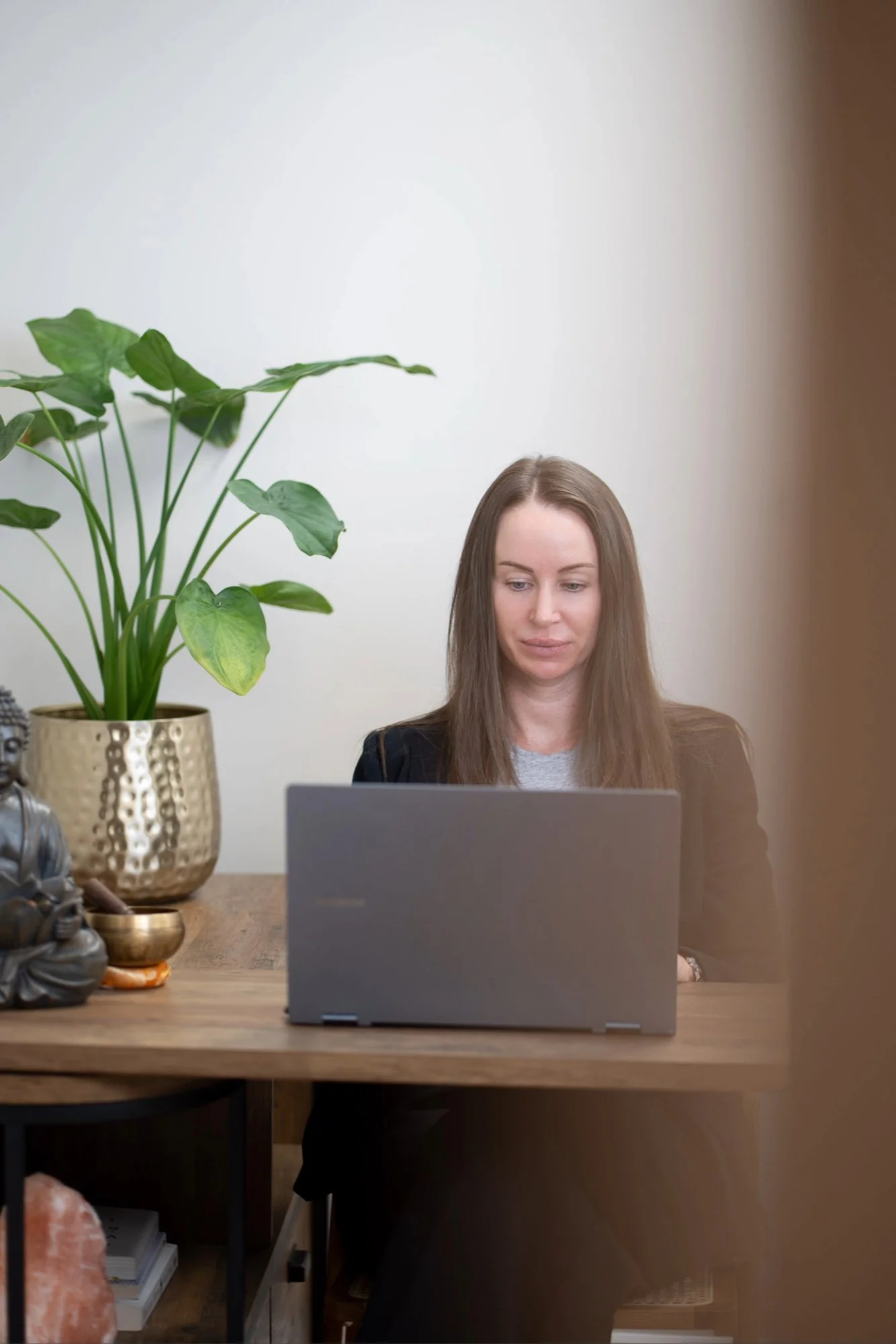 Katie from Kokoro Wellness working on her laptop during an online hypnotherapy session.