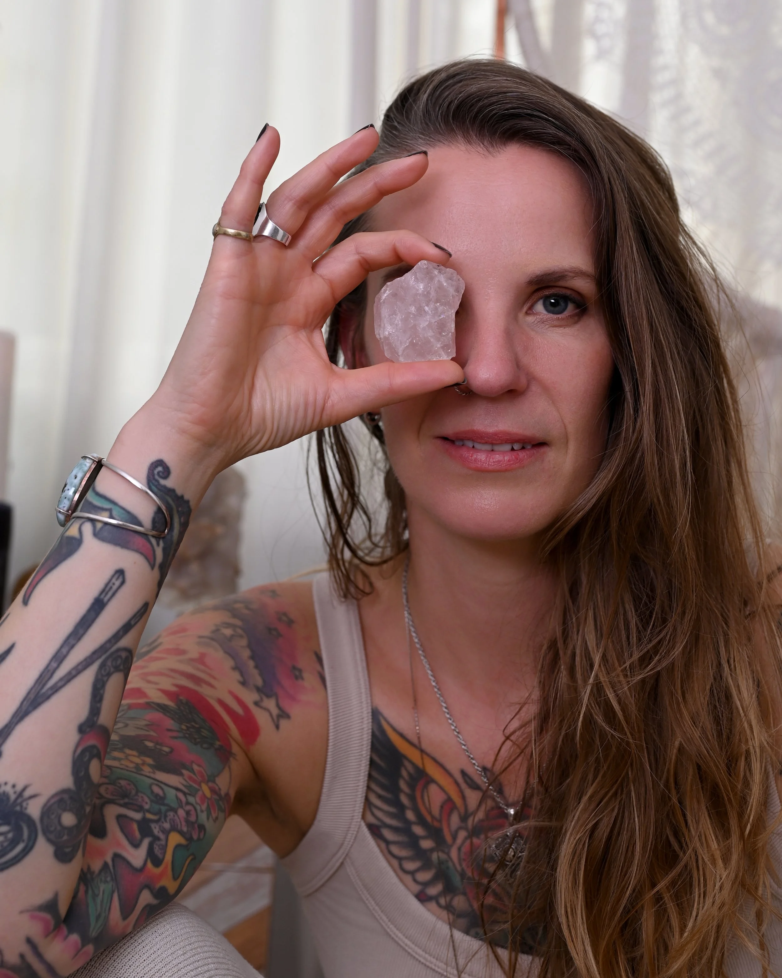 Client holding a crystal to her eye during a soulful brand shoot, capturing intuition, energy and spiritual alignment.