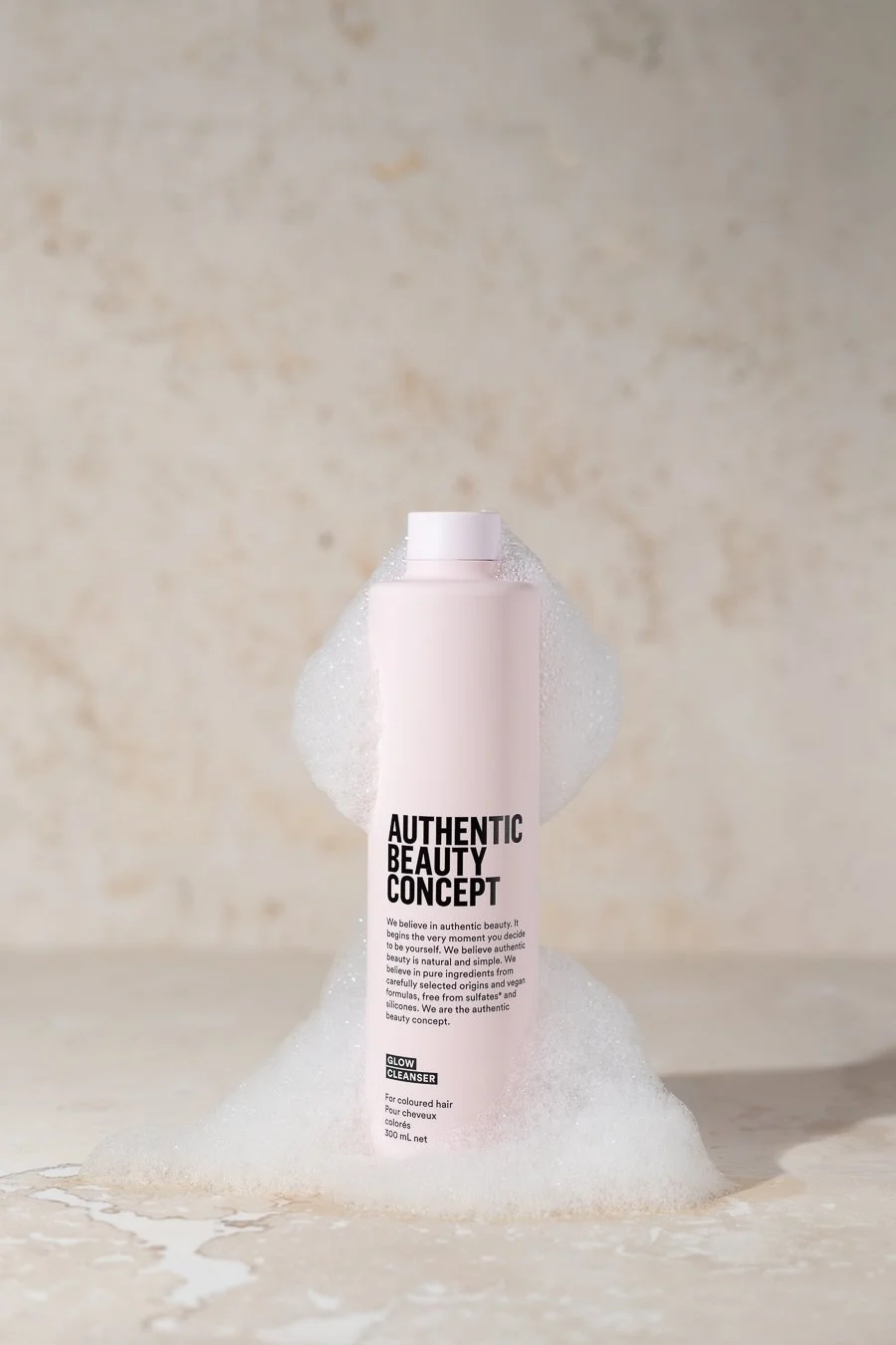 Product photography of Authentic Beauty Concept shampoo with foam texture, styled for clean beauty campaign imagery.