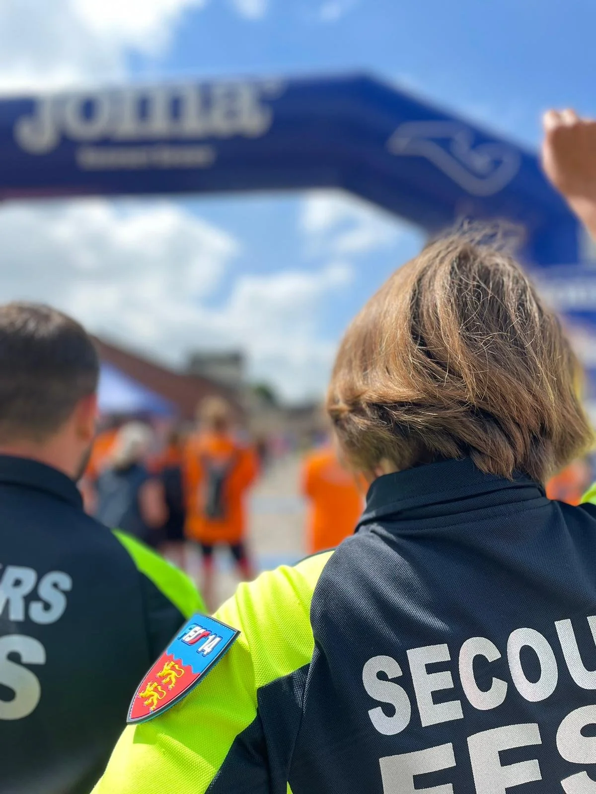 Bénévole secouriste encourageant des coureurs.
