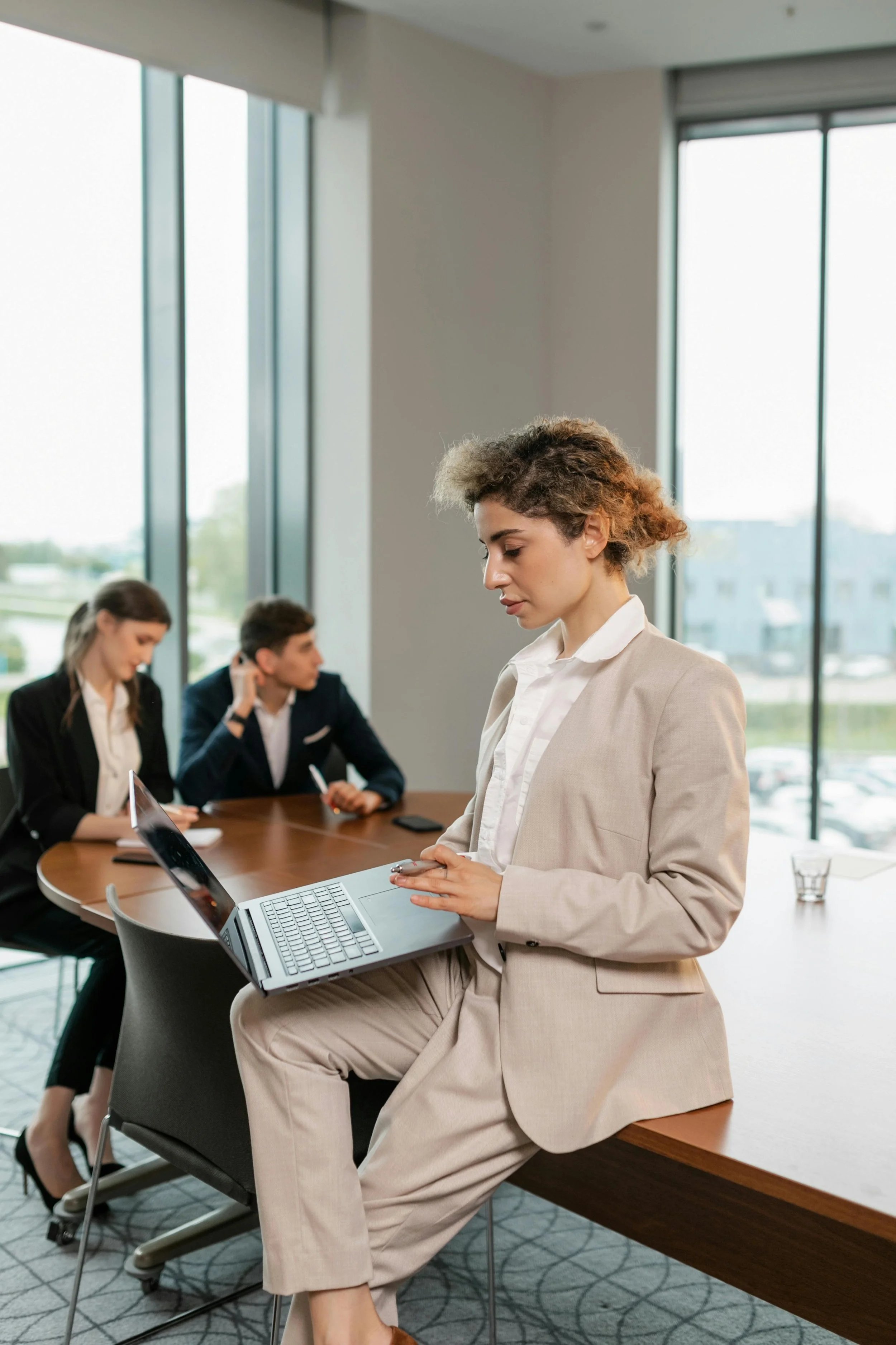HR professional reviewing information on a laptop during a team meeting, representing the evolving leadership skills and people-focused priorities shaping modern HR teams.