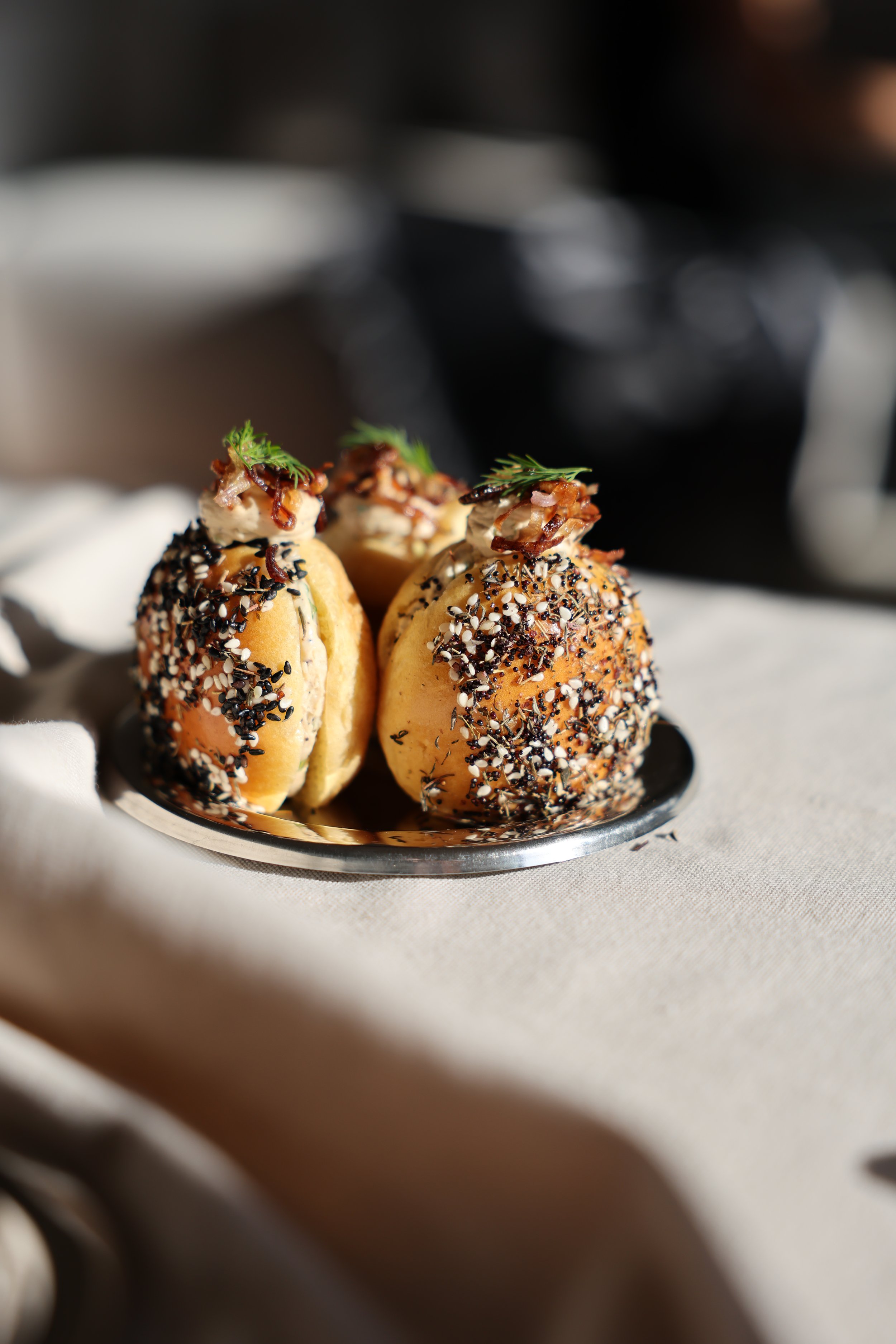 Petits pains garnis avec des graines de sésame et de nigelle, décorés de feuilles de coriandre