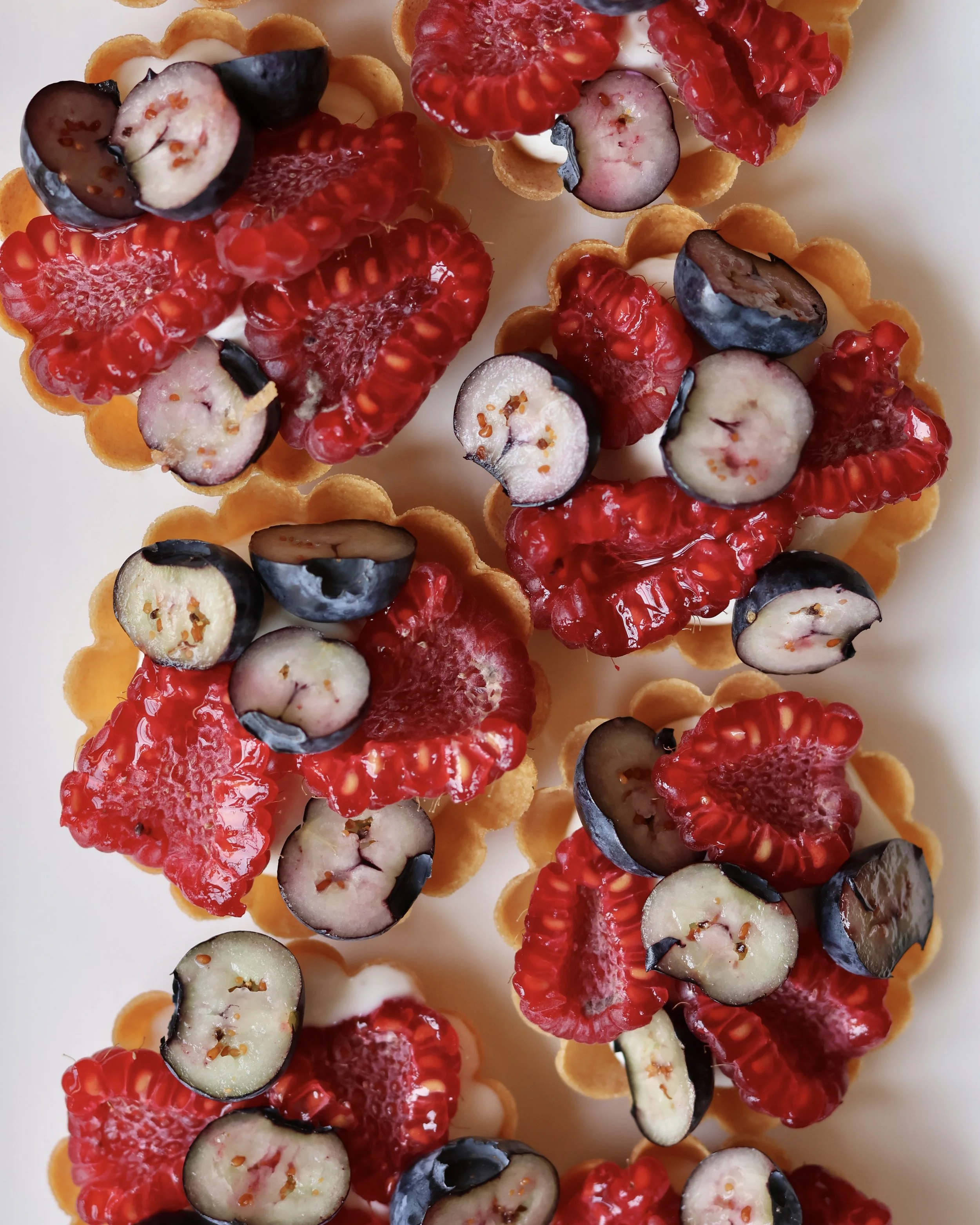 Tartelettes aux fruits rouges avec biscuits, crème et garniture de fraises, myrtilles et mûres.