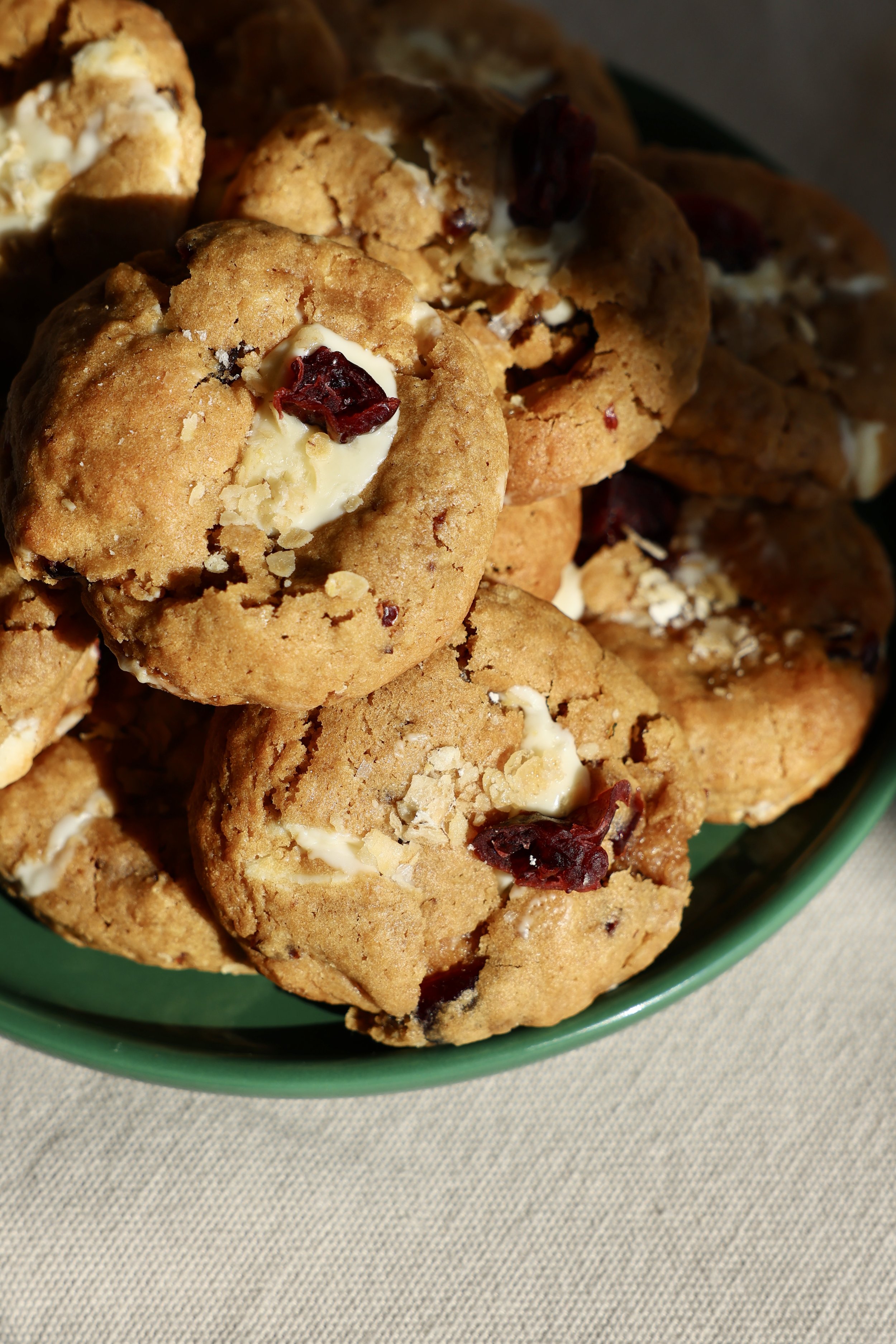 Cookies aux cranberries blanches dans un bol vert.
