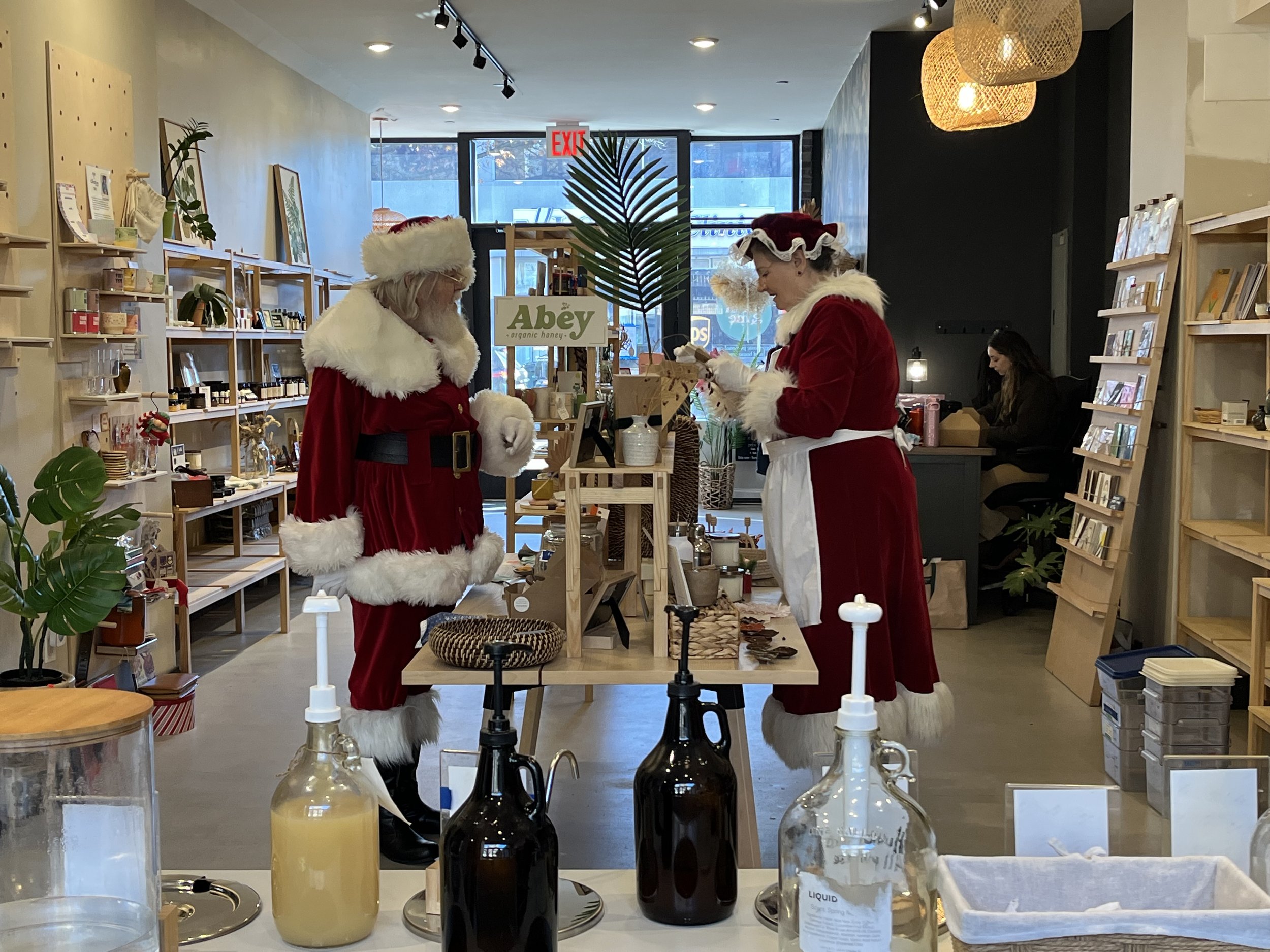  Santa and Mrs Claus browse products in a shop. 