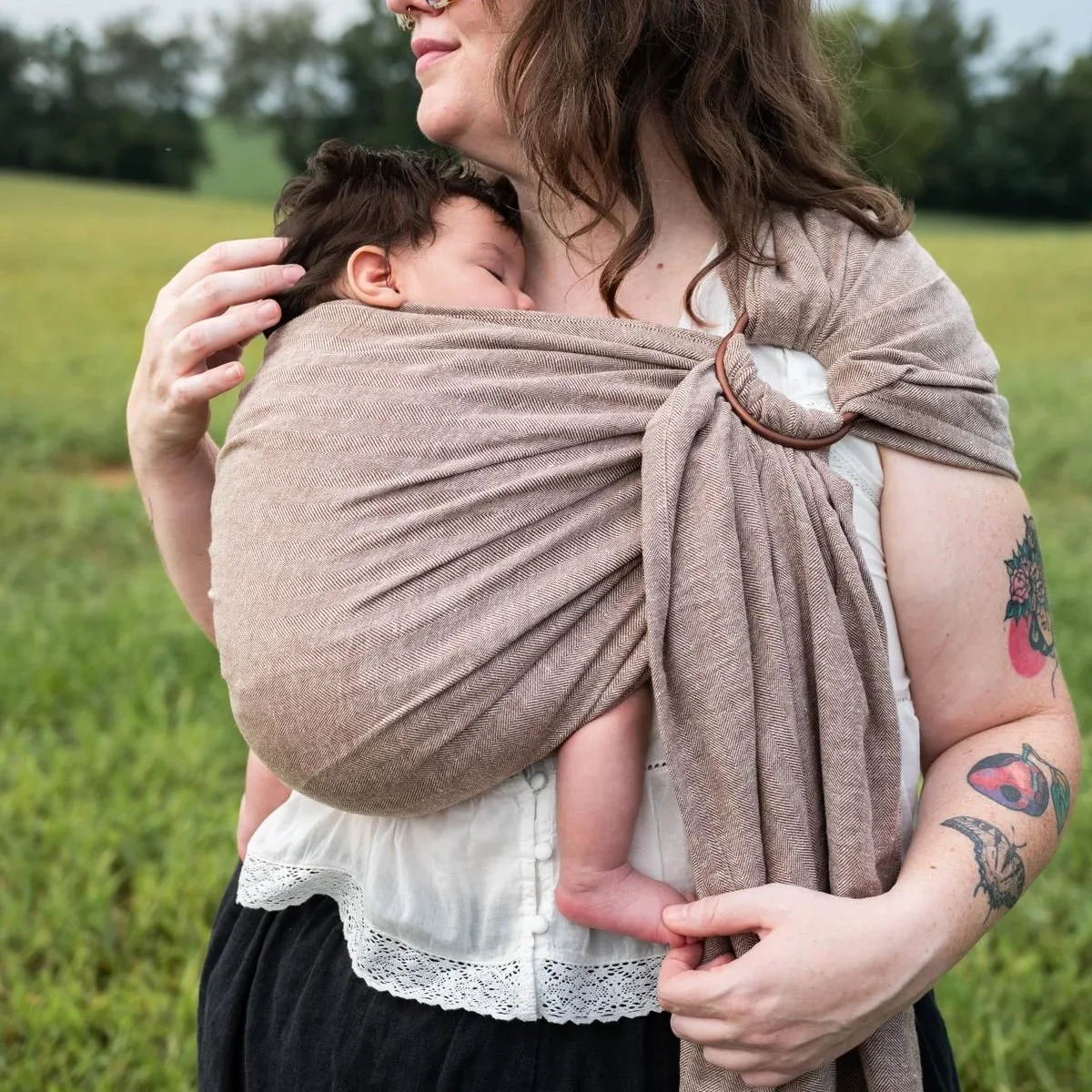 Mom wearing baby in ring sling.