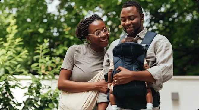 Dad wearing baby in baby carrier.