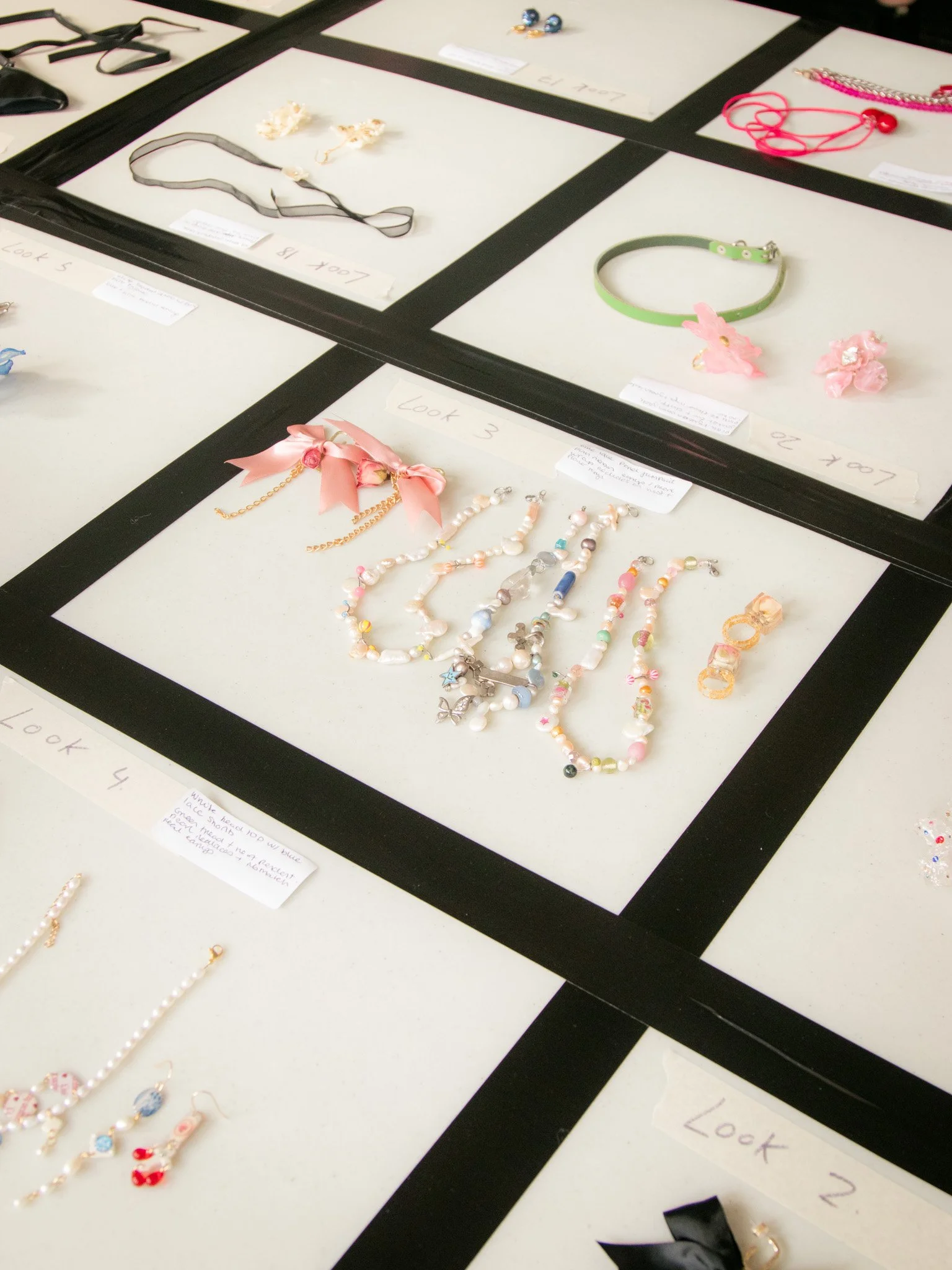 	
Display of various handmade jewellery including necklaces, bracelets, earrings, and hair accessories arranged on white display boards with handwritten labels for Sinead O'Gorey's fashion show.