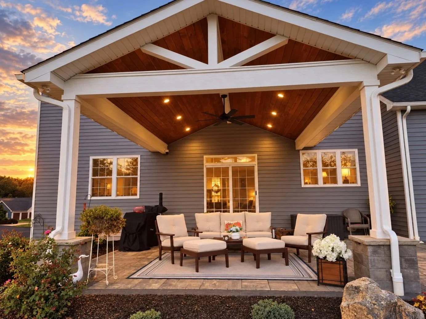 Covered pavilion seating area overlooking backyard landscaping