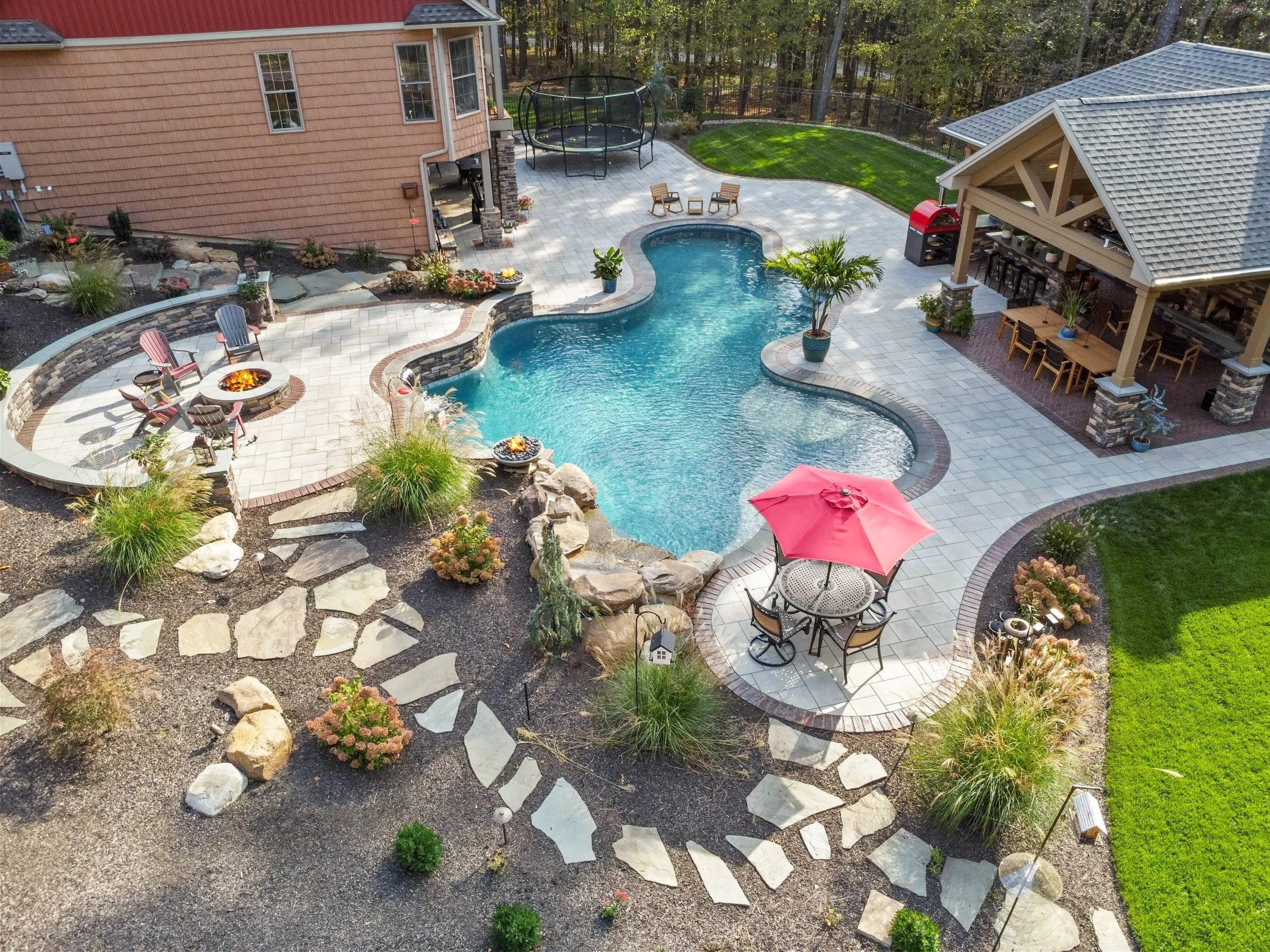 Custom poolside landscaping with stone steps and lighting in Susquehanna Township, PA